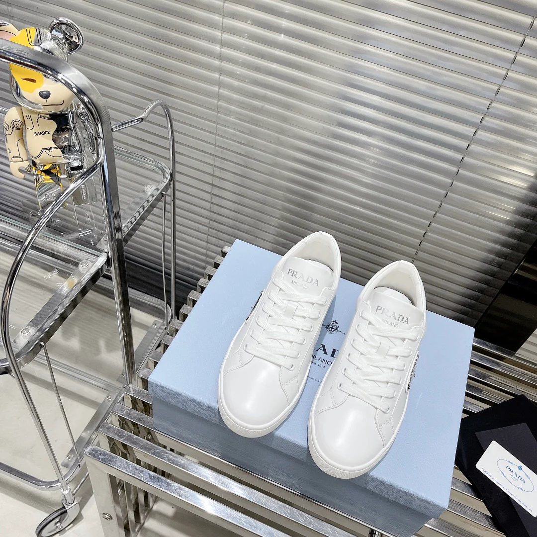 Белые повседневные кроссовки Prada с треугольным логотипом — парный стиль.