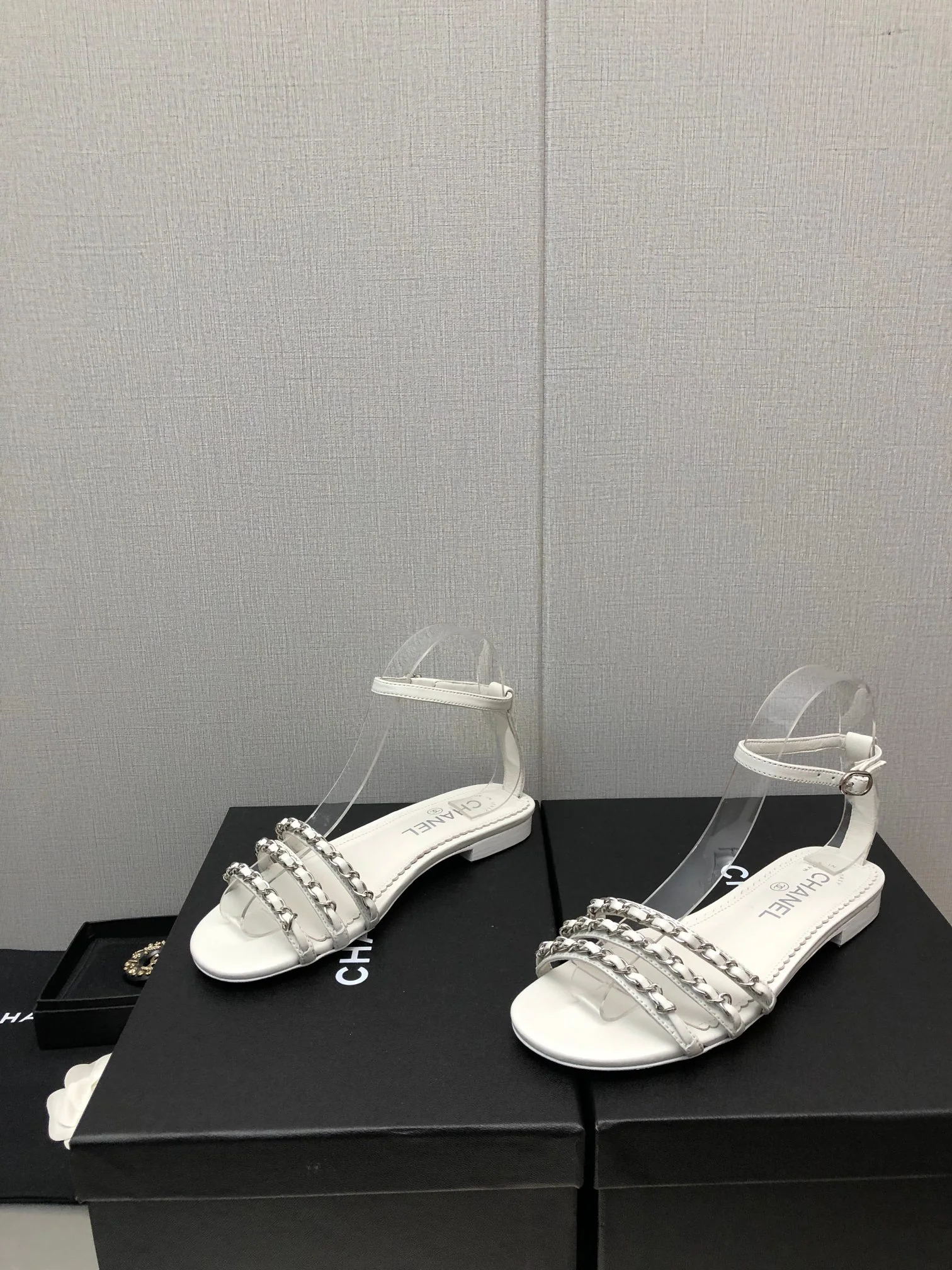 Новинка весны 2023 года от Chanel - сандалии на плоской подошве с цепочкой - белые.