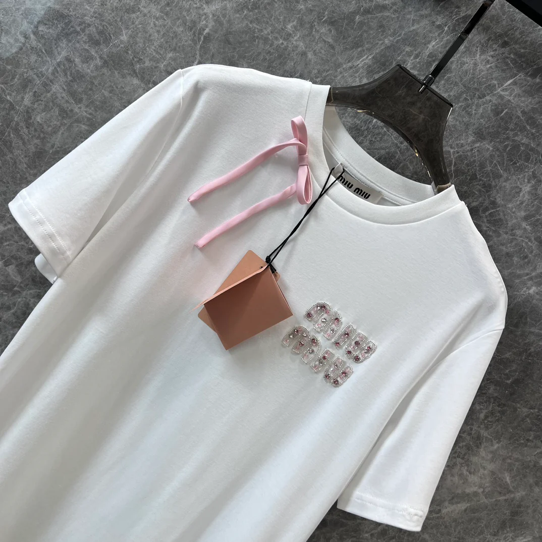 Miu Miu-2404 - Розовая атласная футболка с короткими рукавами и бантом из ленты, украшенная стразами в виде букв.