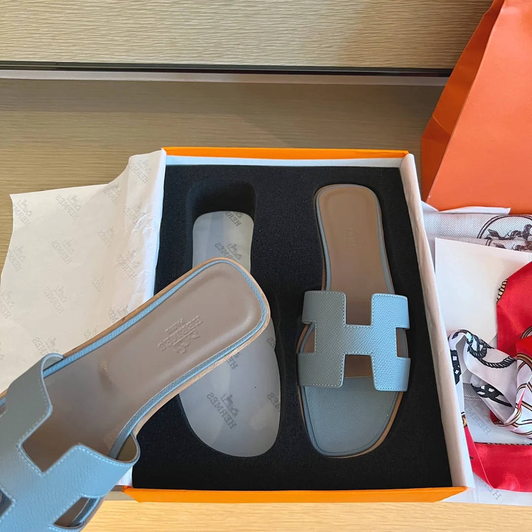 Классические тапочки Hermes с буквой H — светло-голубые с принтом пальм.