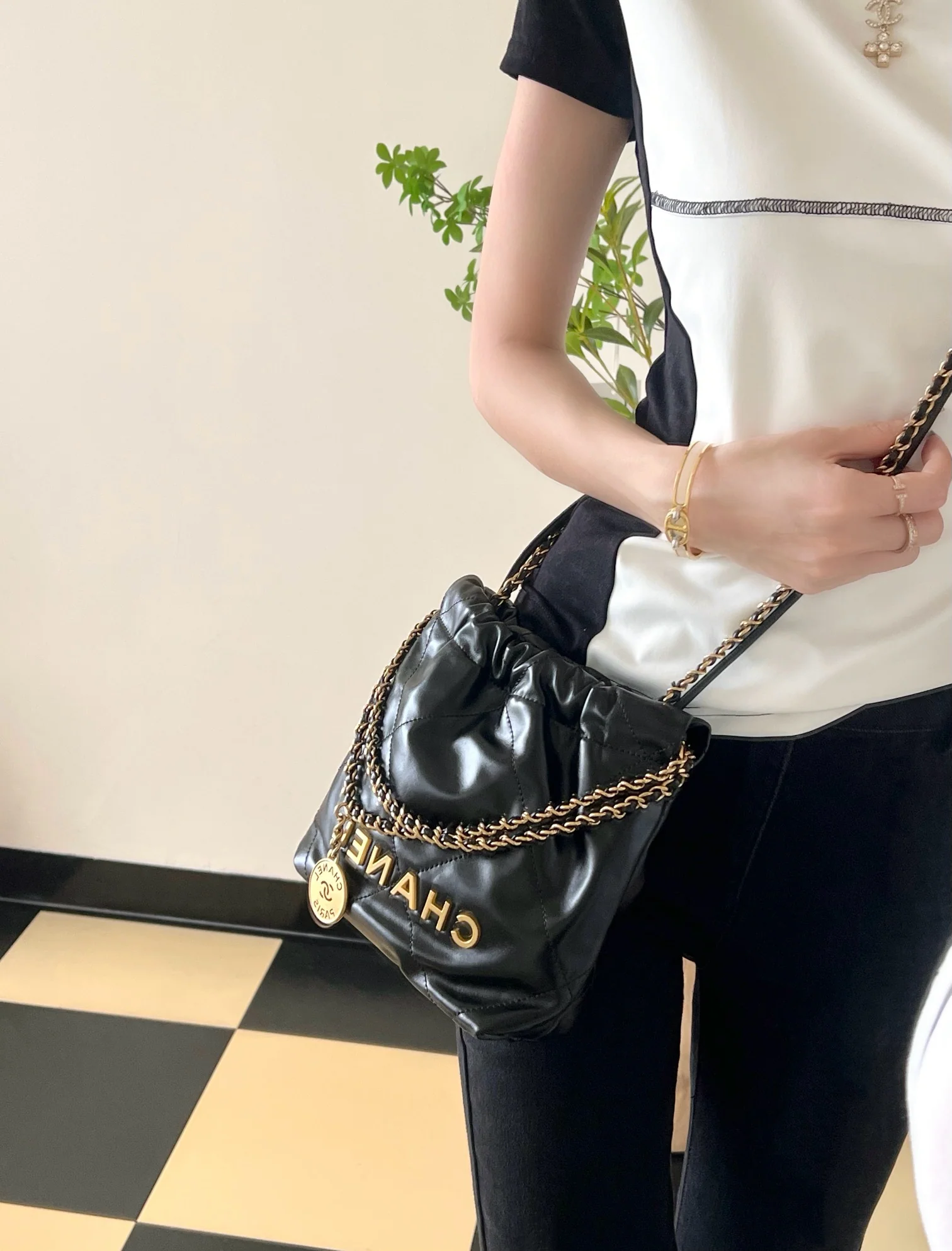 Мини-сумочка Chanel 22 – черная с золотой фурнитурой.