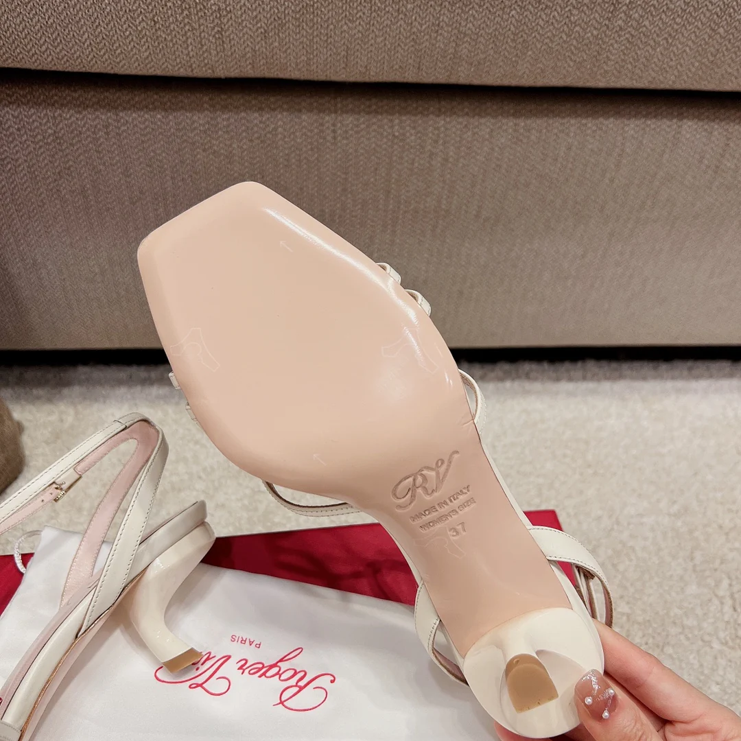 Сандалии RV Shoes - белые, с квадратной пряжкой, на низком каблуке и ремешками.