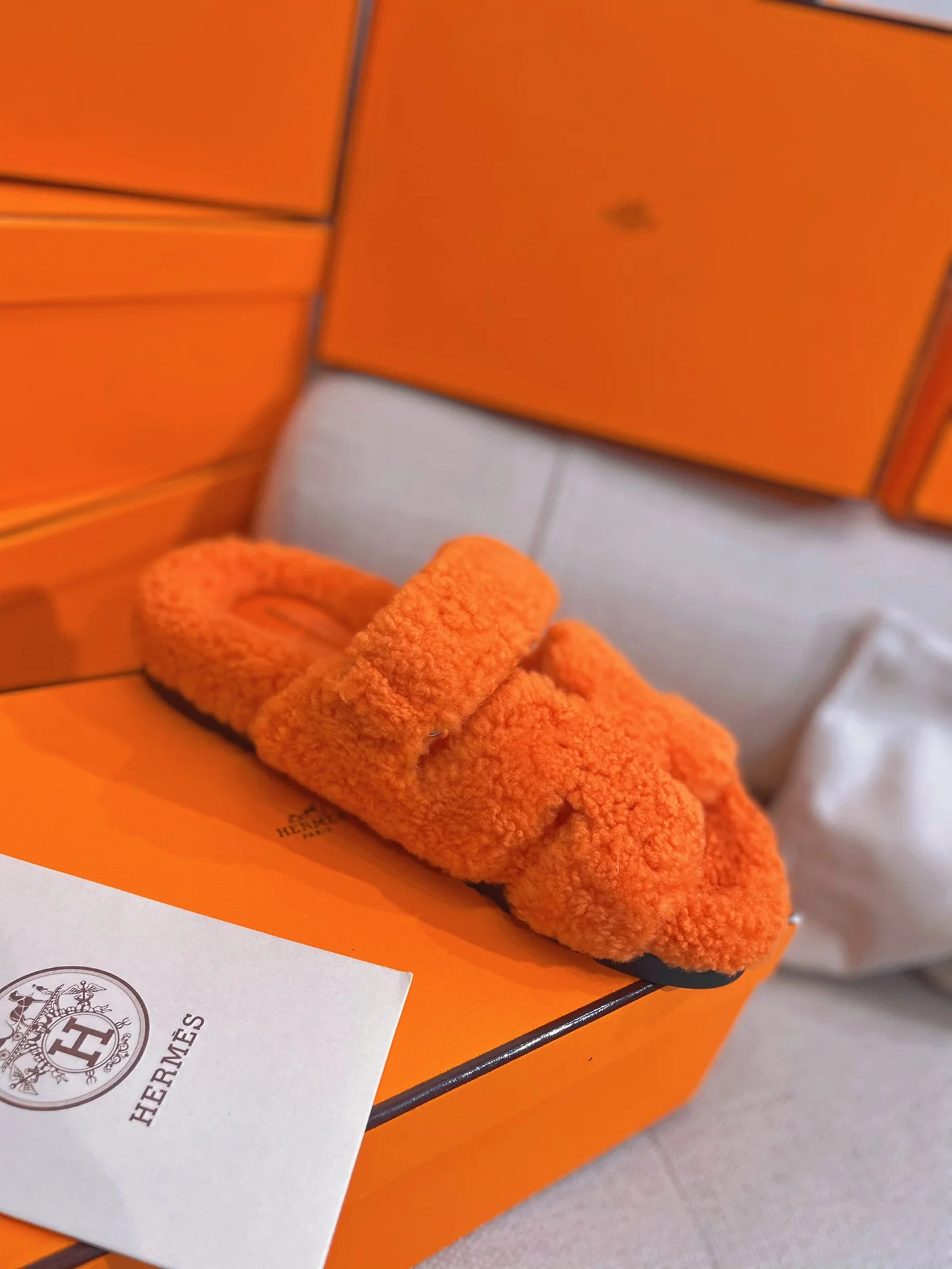 Новинка осенне-зимней коллекции Hermes 2022 — тапочки H из овечьей шерсти и кожи в стиле пэчворк — оранжевые.