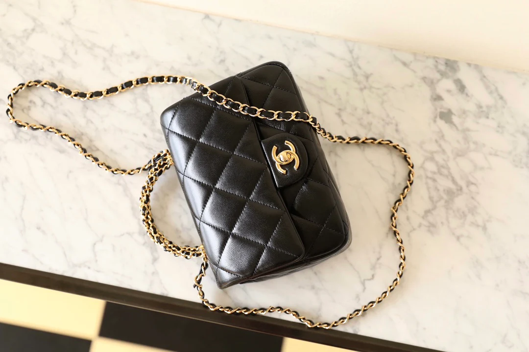 Маленькая черная сумка Chanel с клапаном и поворотной ручкой.