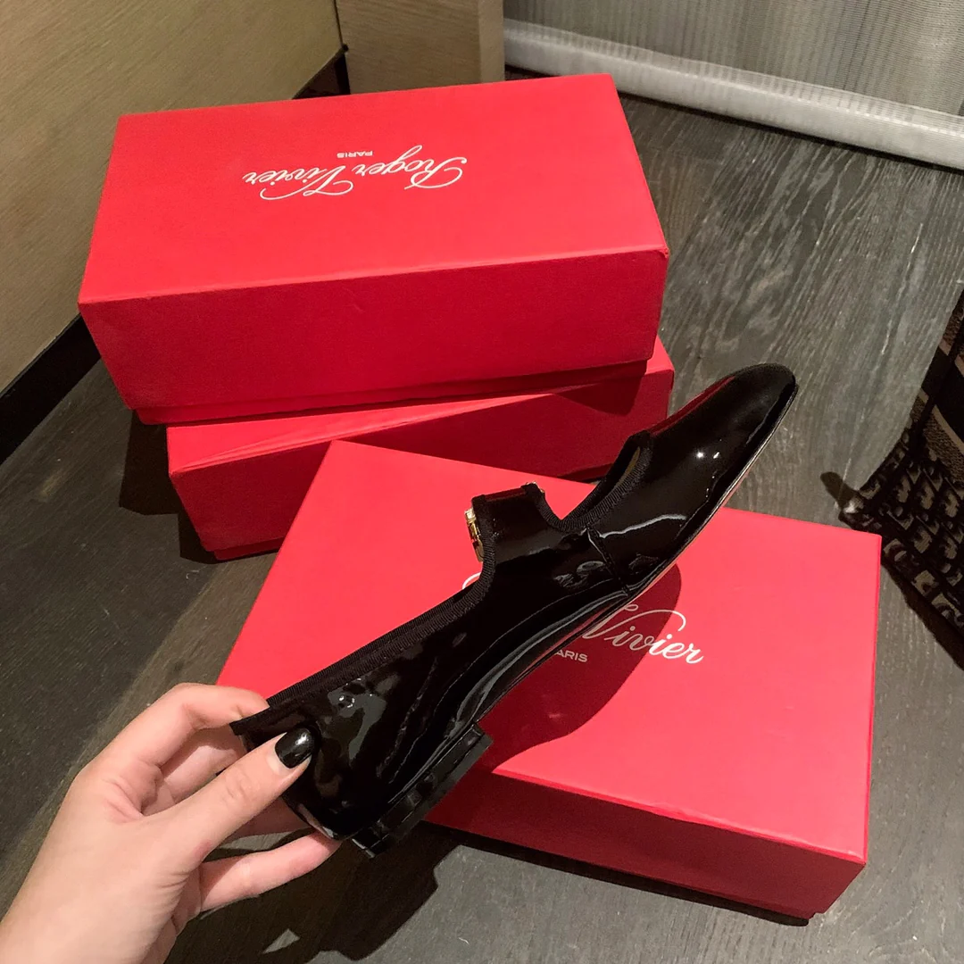 Лакированные балетки с пряжками, украшенными стразами — черные.