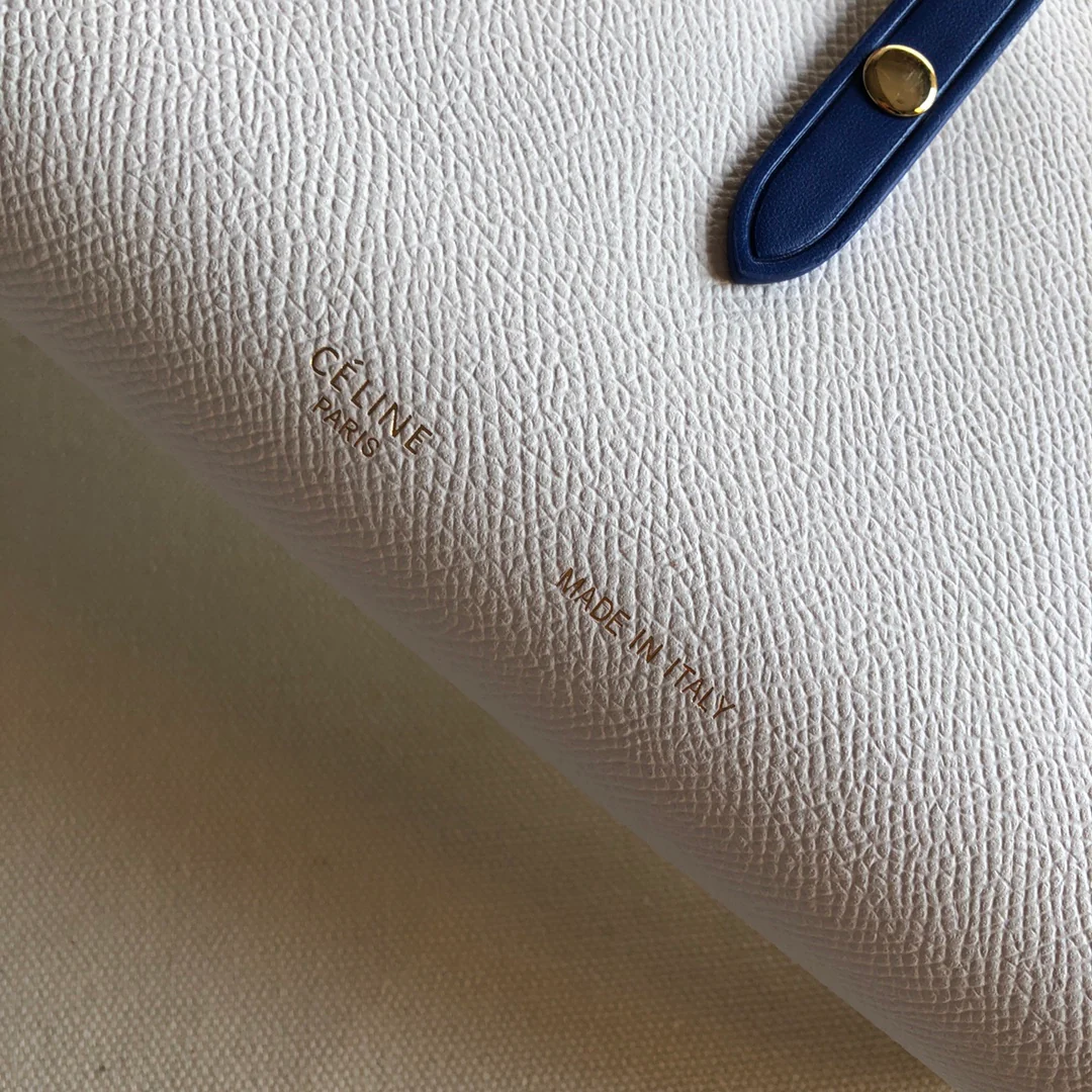 Длинный кошелек Celine — кремовый и синий — с принтом в виде пальмовых листьев.