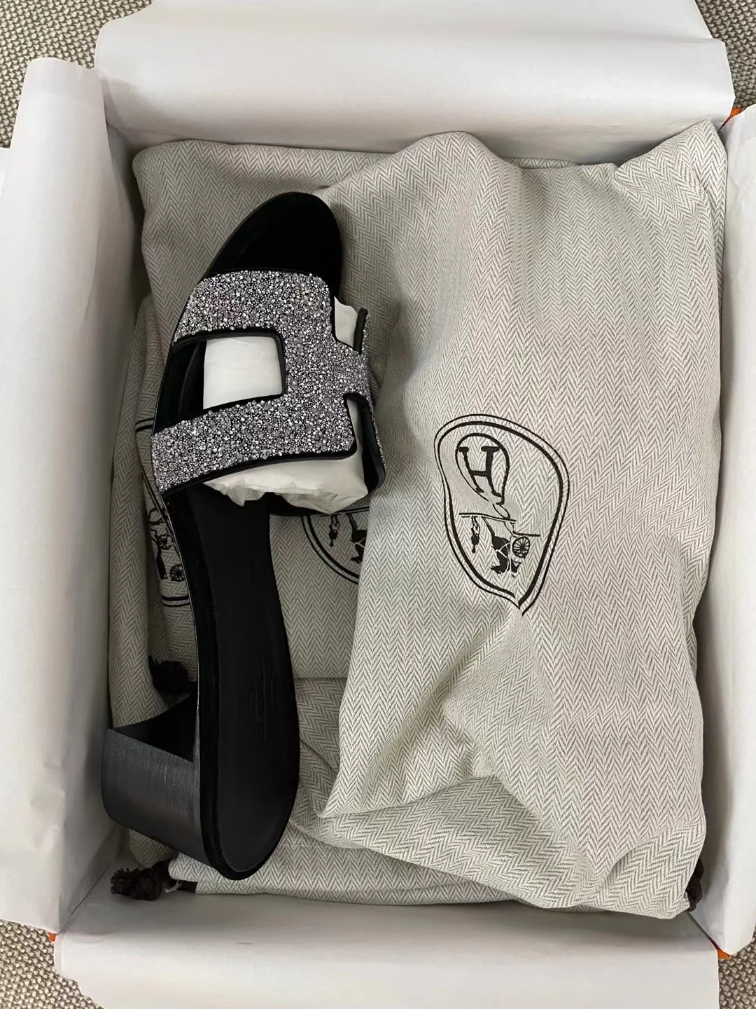 Тапочки Hermes с буквой H — черные с серебряными стразами.