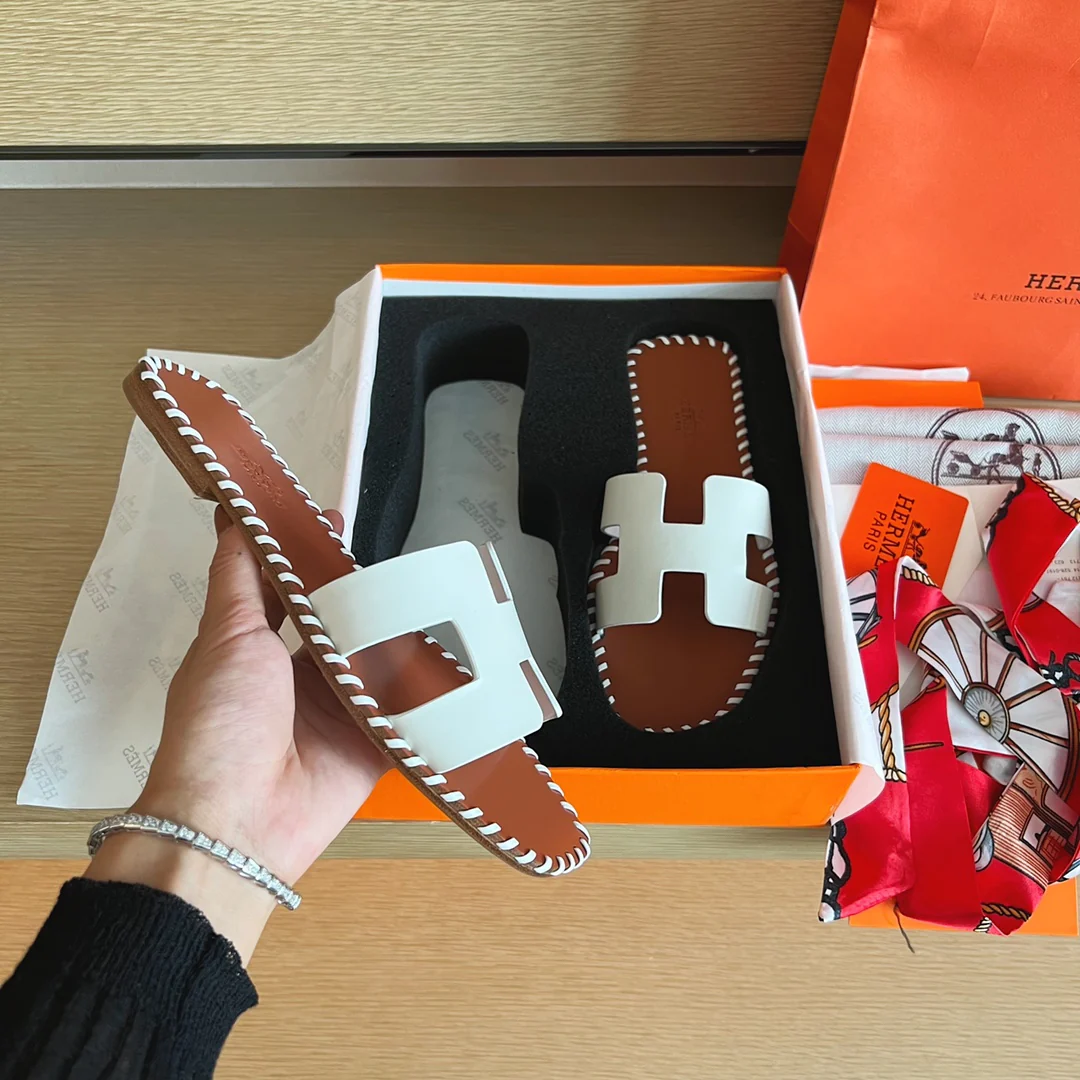 Классические домашние тапочки Hermes с буквой H — верх из однотонной кожи с прошитой подошвой — белые.
