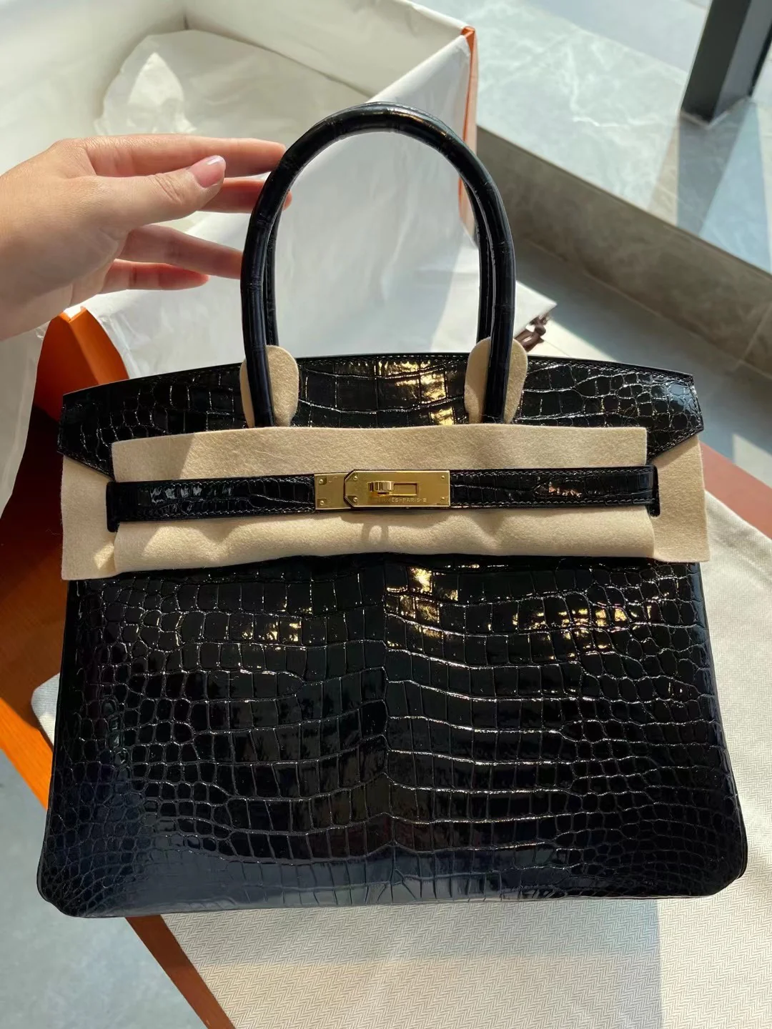 Сумка Hermes Birkin 30 из кожи аллигатора, черная, с золотой пряжкой.
