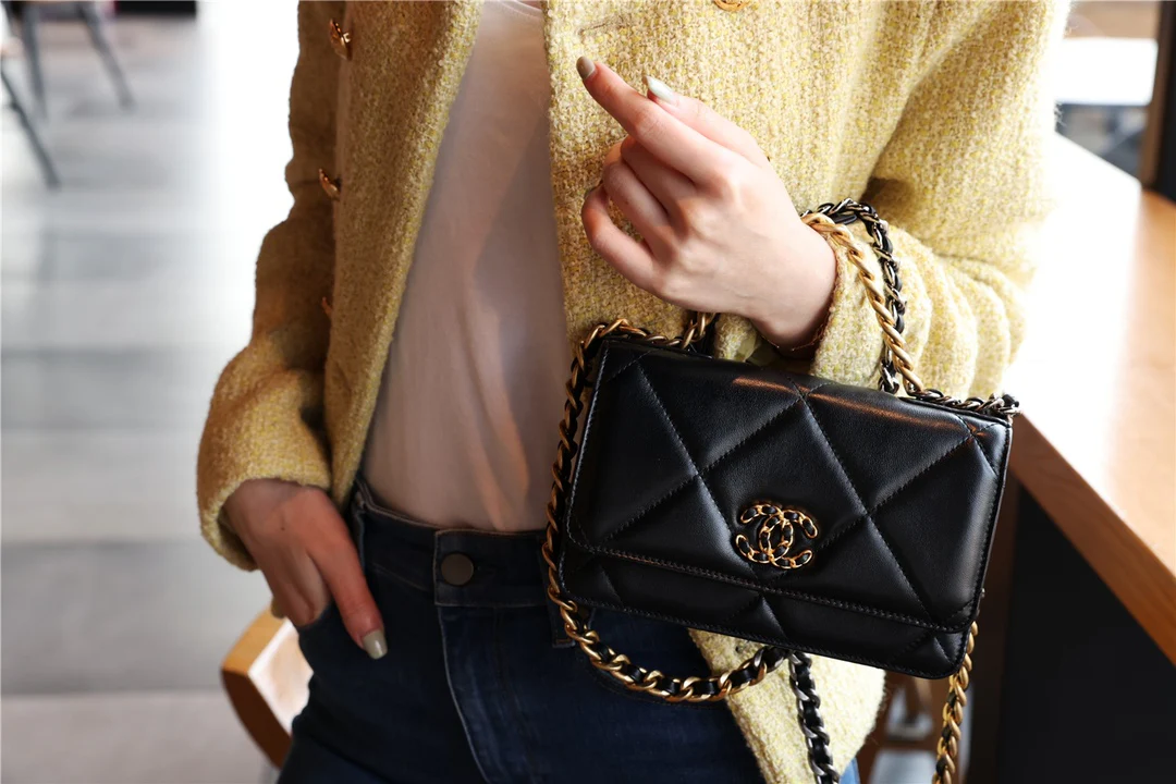 Сумка Chanel WOC из 19-й коллекции - из черной овечьей кожи с золотой пряжкой.