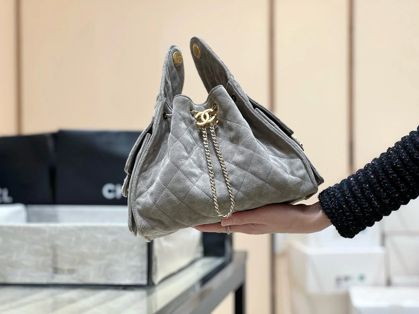 Популярная сумка-хобо Chanel 25c, которую можно носить под мышкой — серо-коричневая.