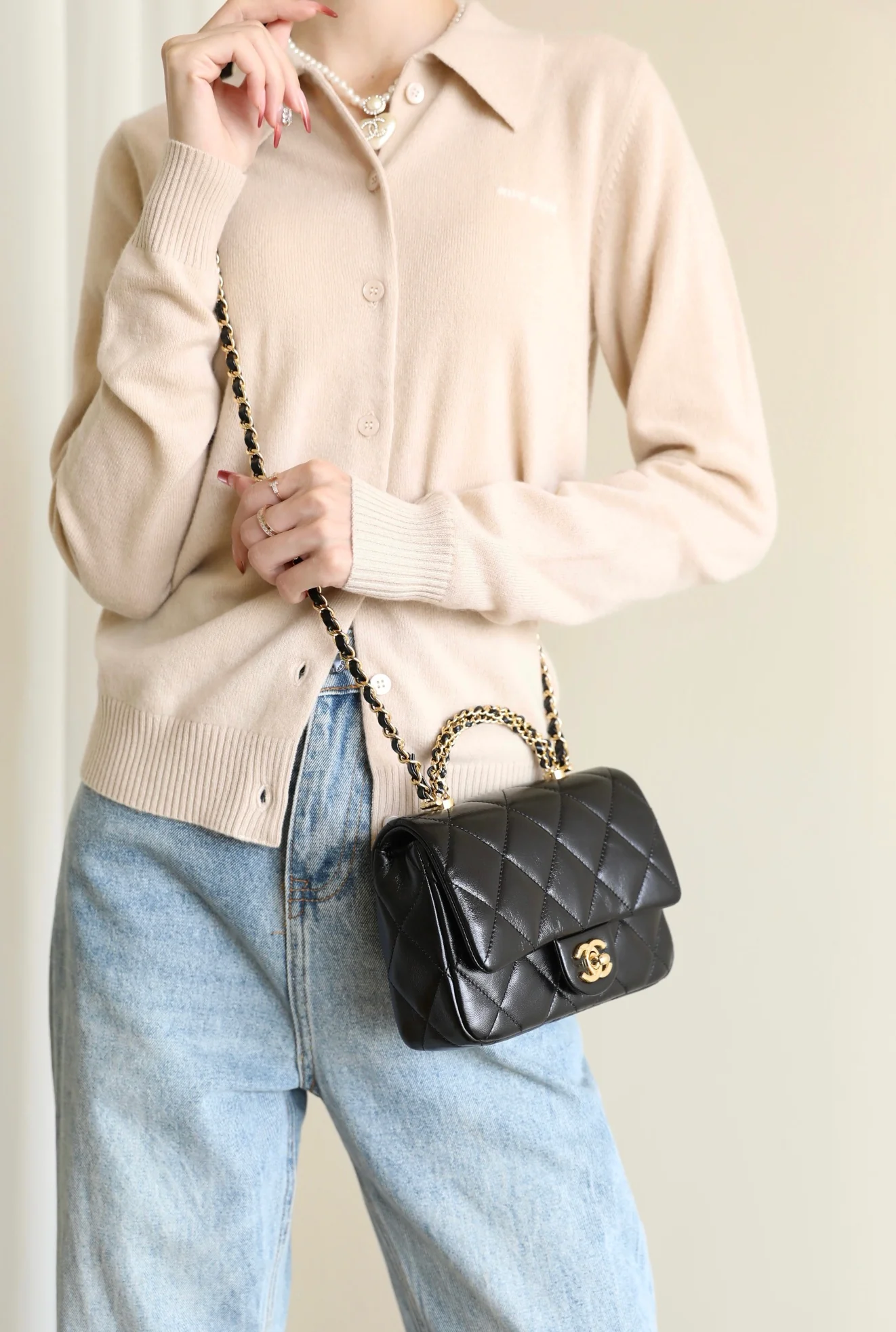 Маленькая черная сумка Chanel с клапаном и поворотной ручкой.