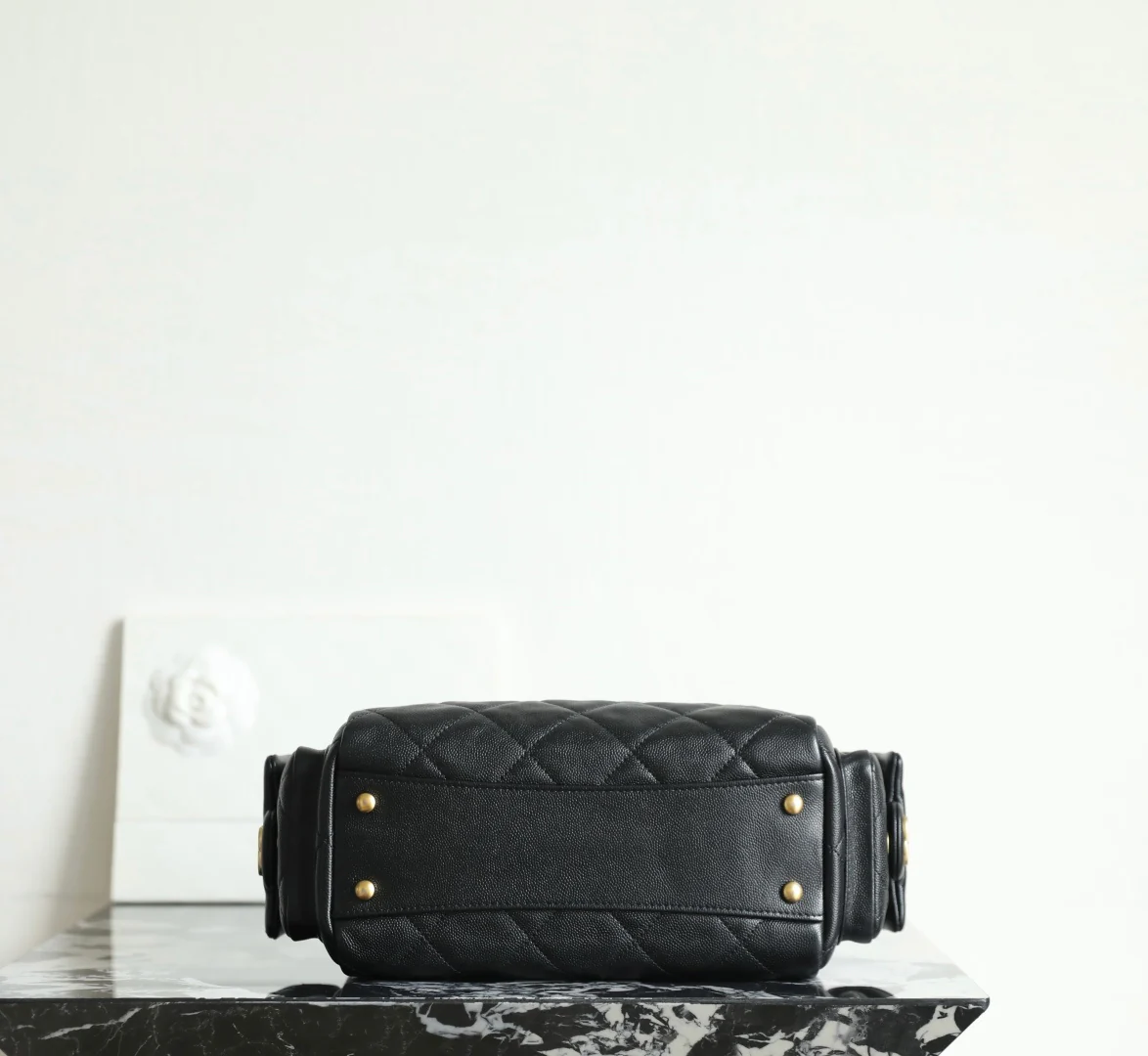 Сумка-боулинг Chanel 25k с двумя карманами — черная кожа с золотой пряжкой и маленьким шариком.