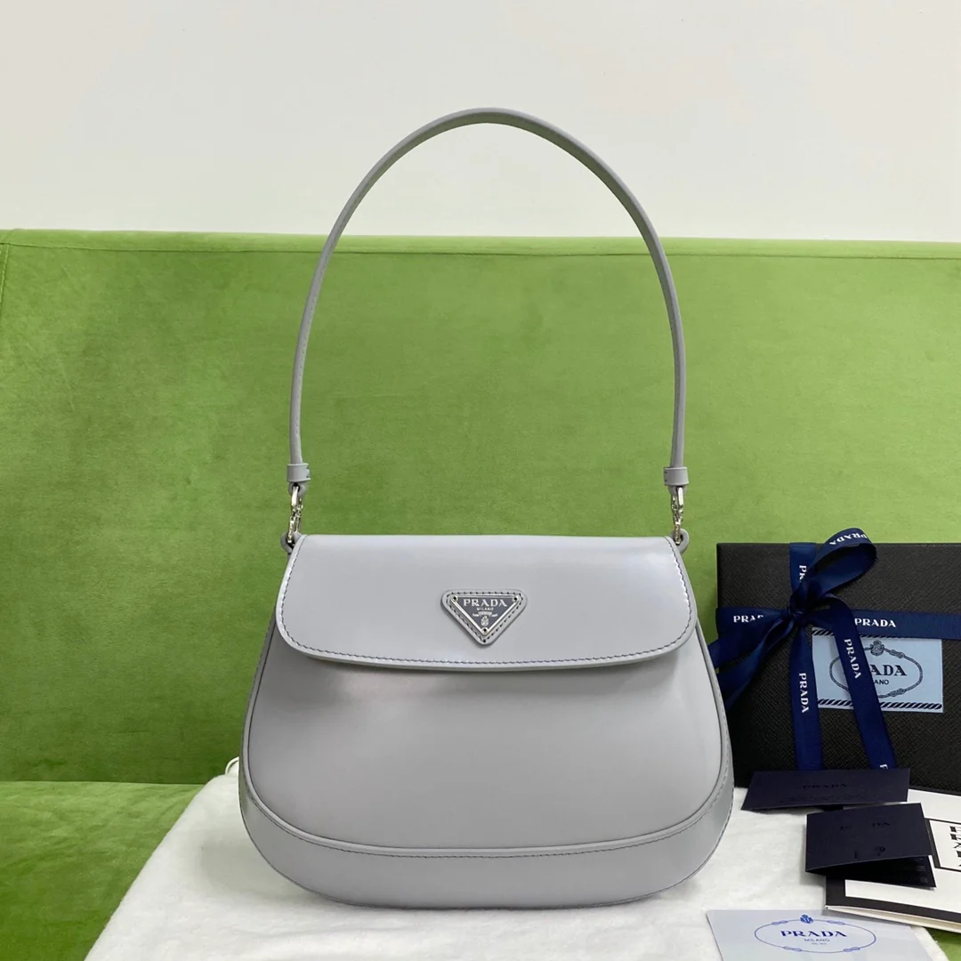 Сумка Prada Cleo через плечо из глянцевой кожи, серо-голубого цвета.