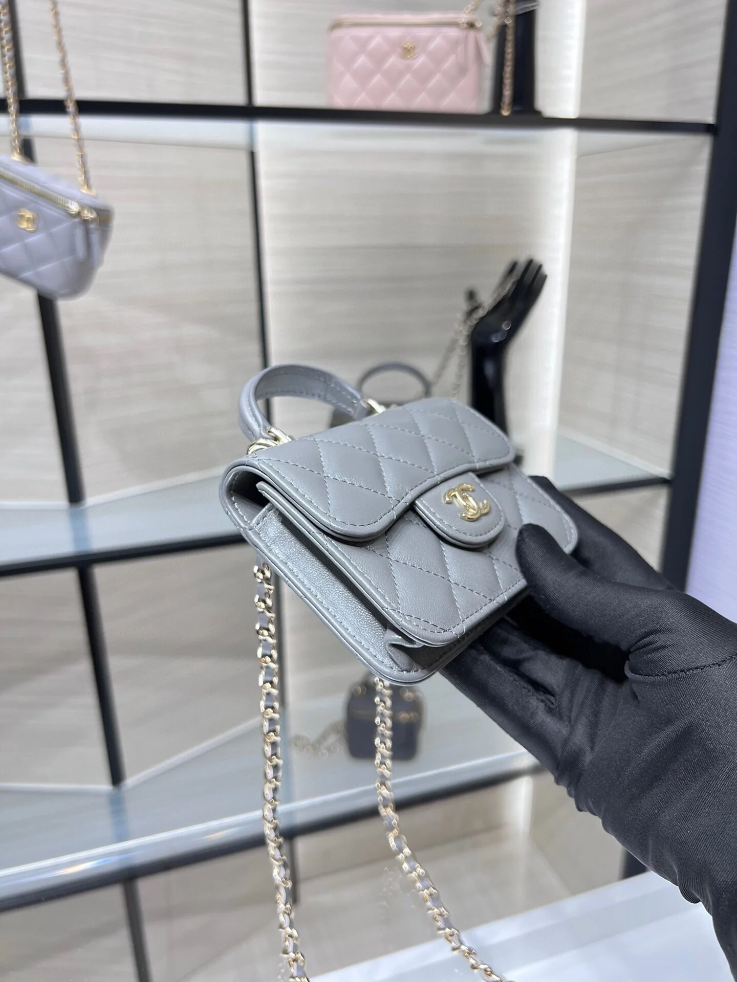 Сумка Chanel из коллекции Métiers d'Art 2022 года — маленькая сумка с цепочкой и ручкой — серая.