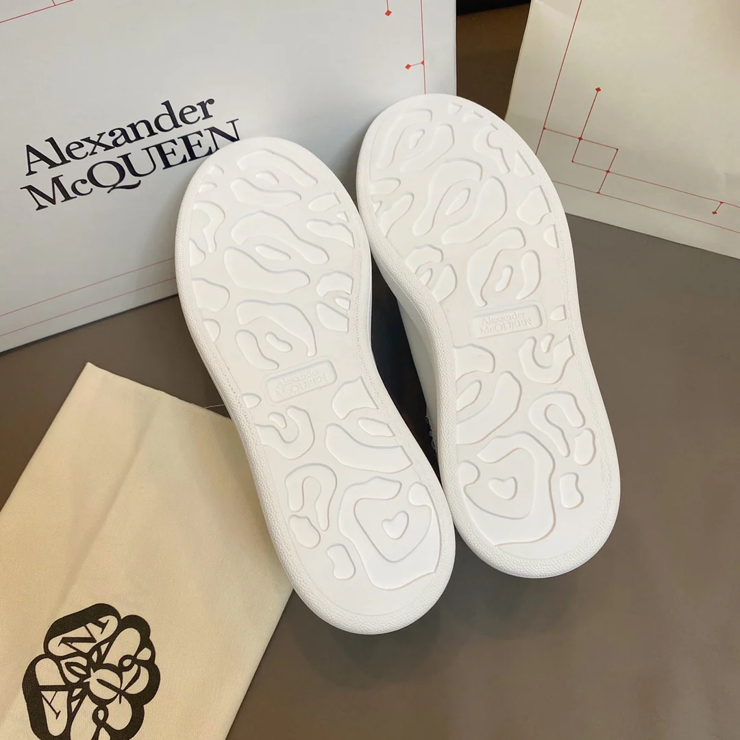 Белые кроссовки McQueen с фиолетовым тиснением под крокодиловую кожу.