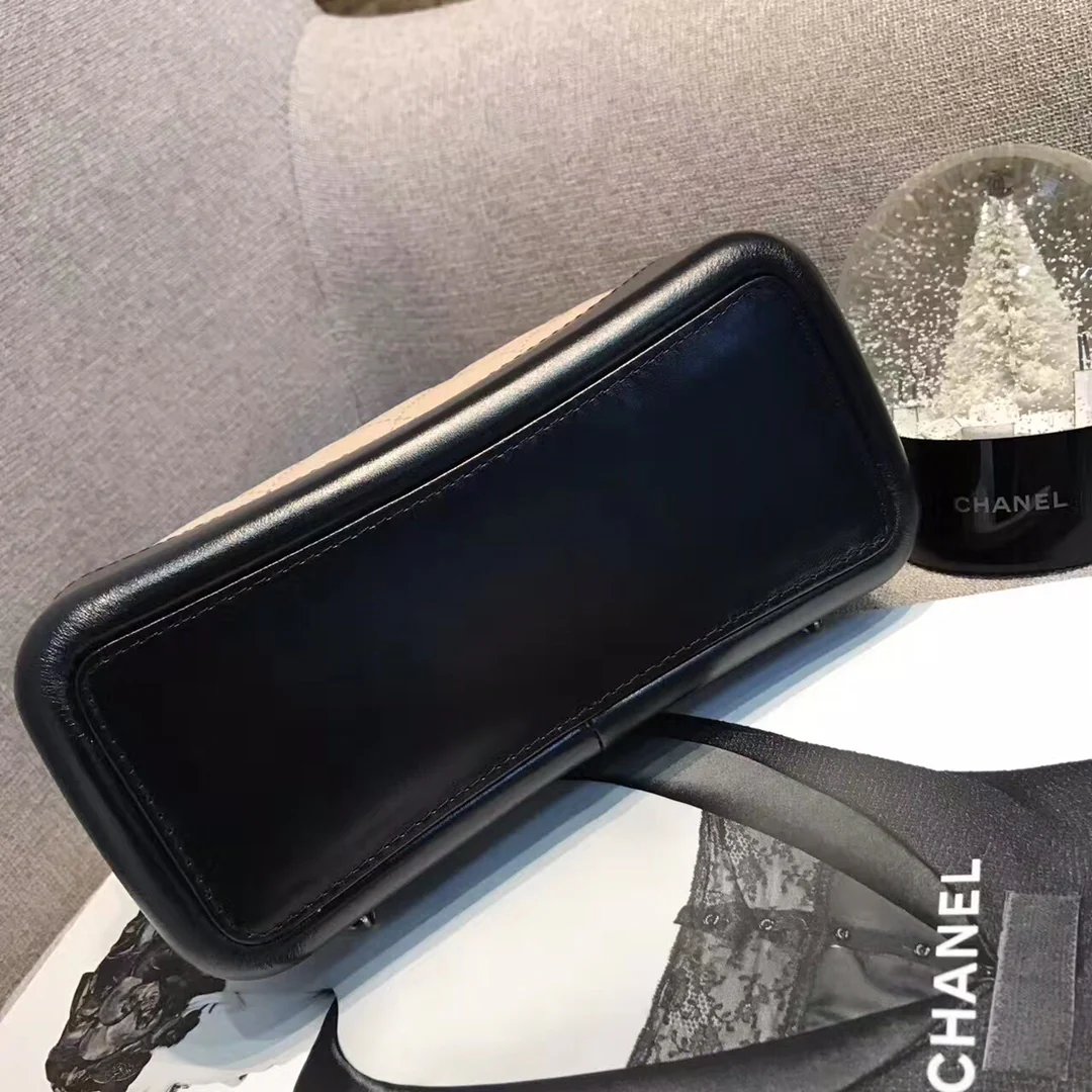 Маленький рюкзак-хобо Chanel — бежевый и черный.