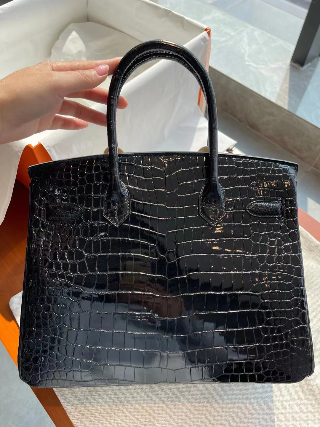 Сумка Hermes Birkin 30 из кожи аллигатора, черная, с золотой пряжкой.