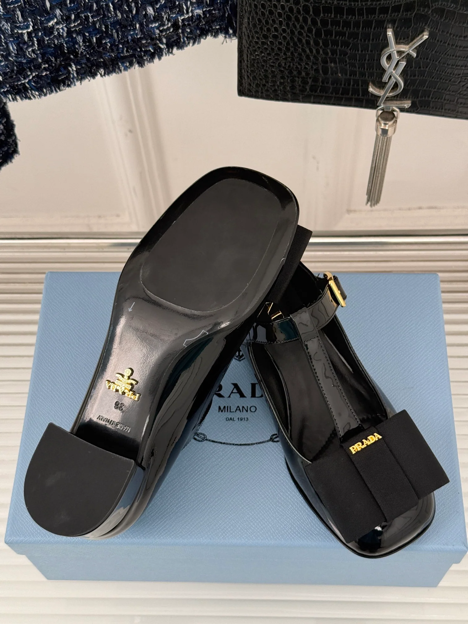 Классические туфли-мэри-джейн Prada с Т-образным ремешком и бантом, закругленным носком, глянцевые, черные.