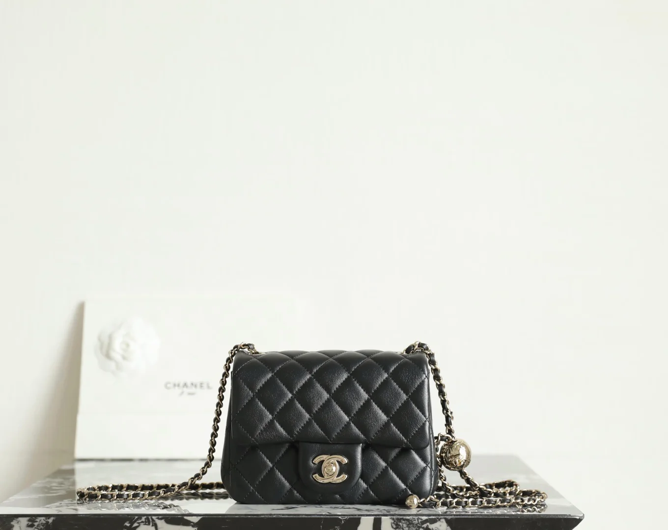 Сумка-шар Chanel из 25-каратного золота с регулируемой застежкой, черная с фурнитурой из светлого золота.