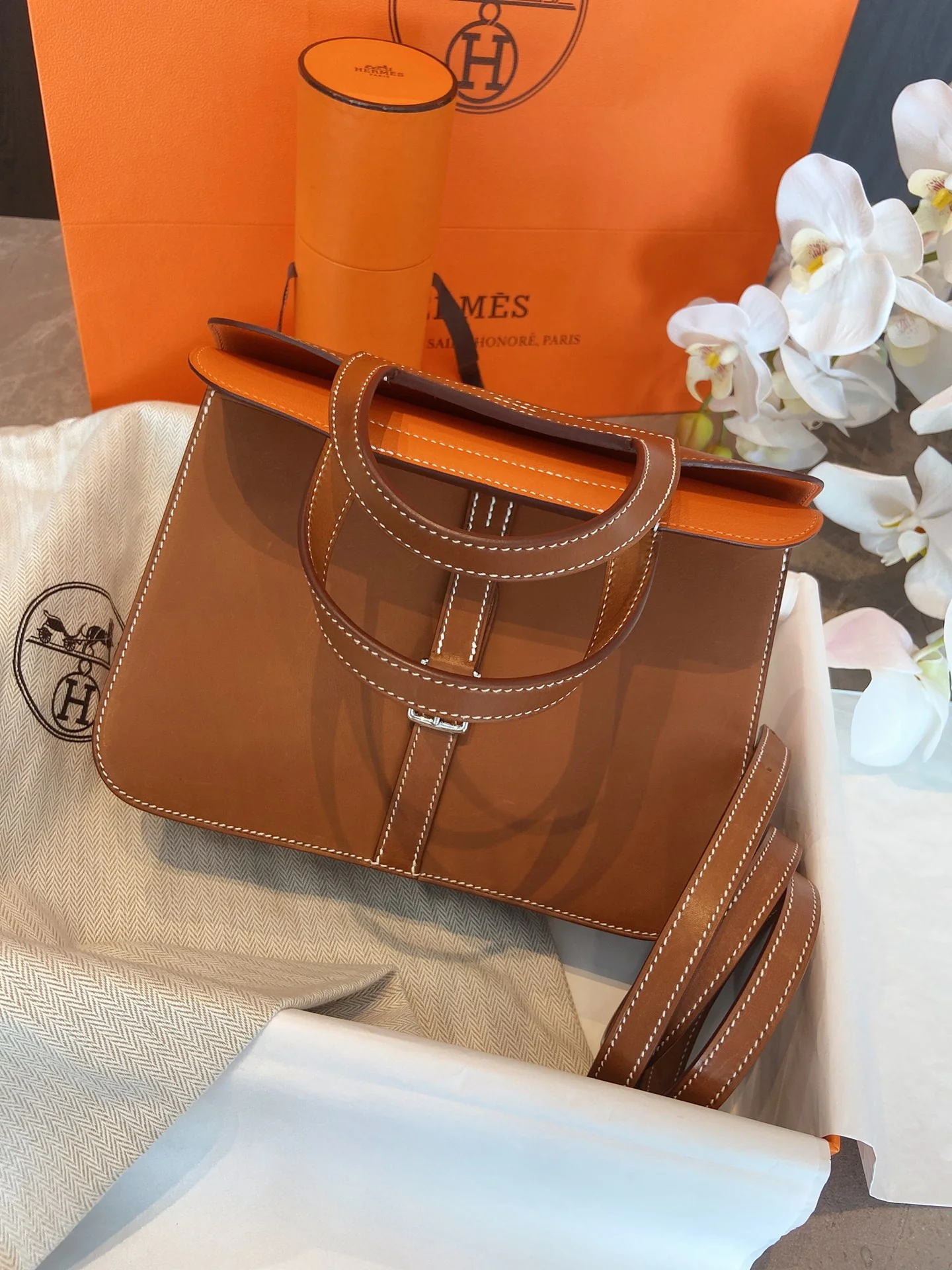 Кожаная сумка Hermes Halzan 25 с оранжевыми акцентами и серебряными пряжками.