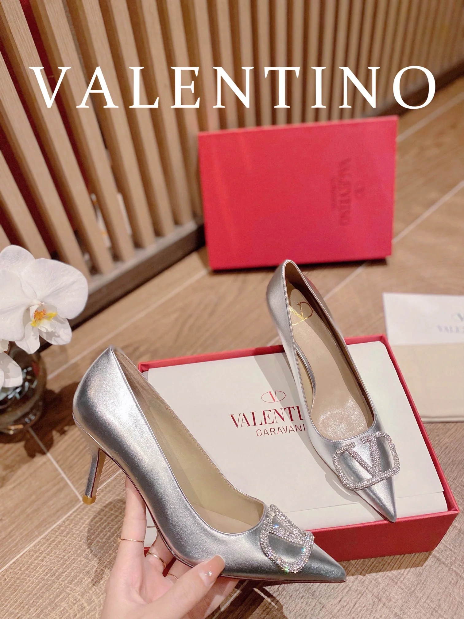 Туфли Valentino на каблуке с V-образным вырезом и бриллиантовой пряжкой — серебристые.