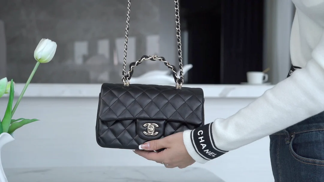 Металлическая ручка Chanel с двойной буквой C, кожаный ремешок, застежка из светлого золота, черный цвет.