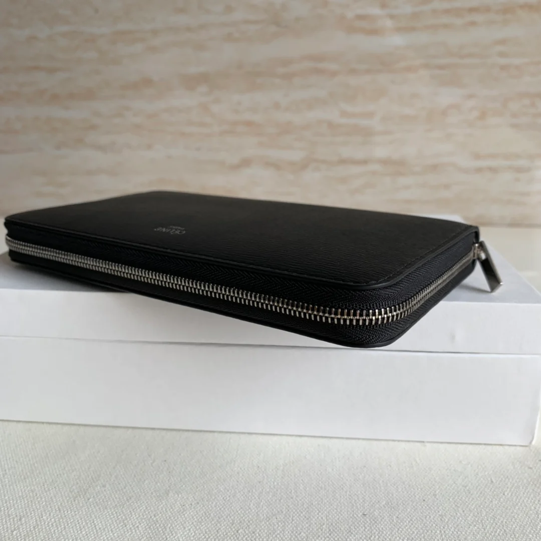 Длинный кошелек Celine на молнии — черный с узором в виде ряби на воде.