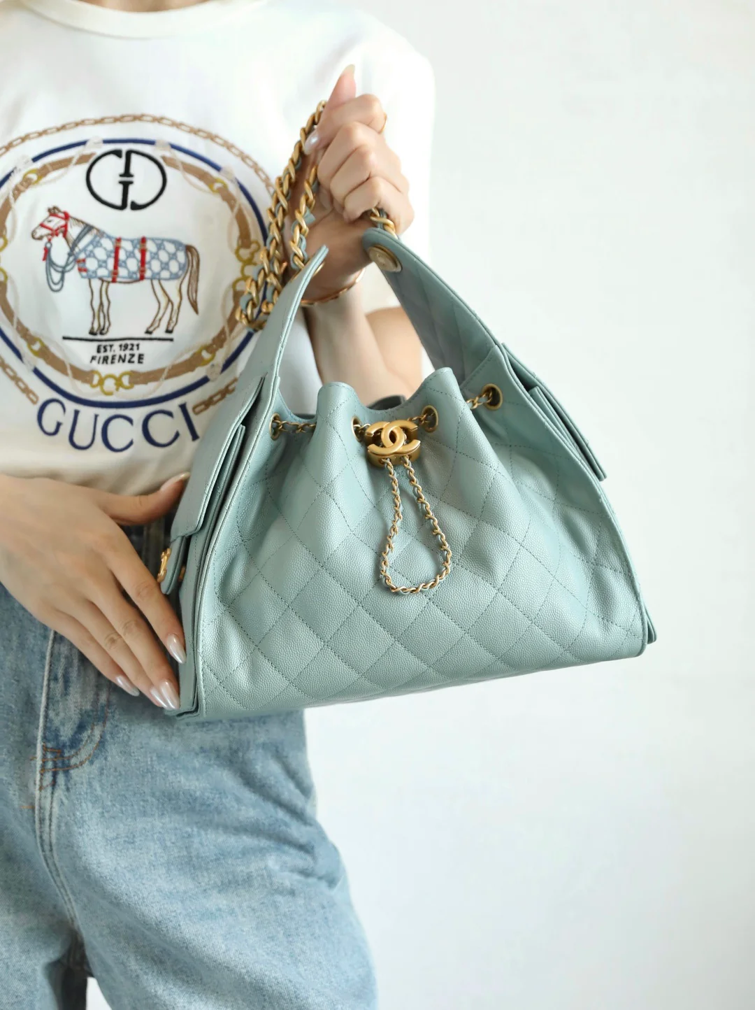 Маленькая сумка-шоппер Chanel — серо-голубая с золотой фурнитурой.