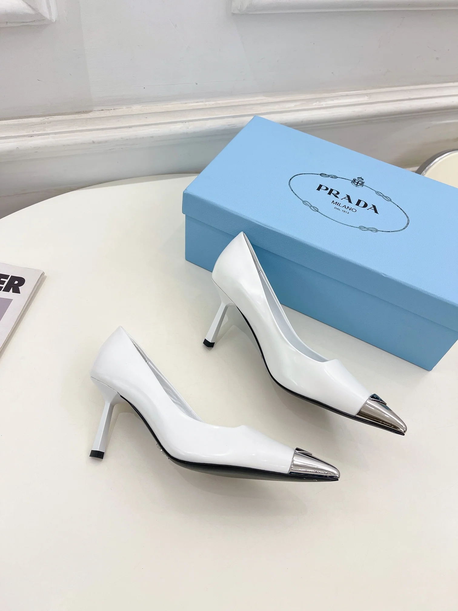 Новинка весны 2023 года от Prada - туфли на высоком каблуке с острым носком - белые.