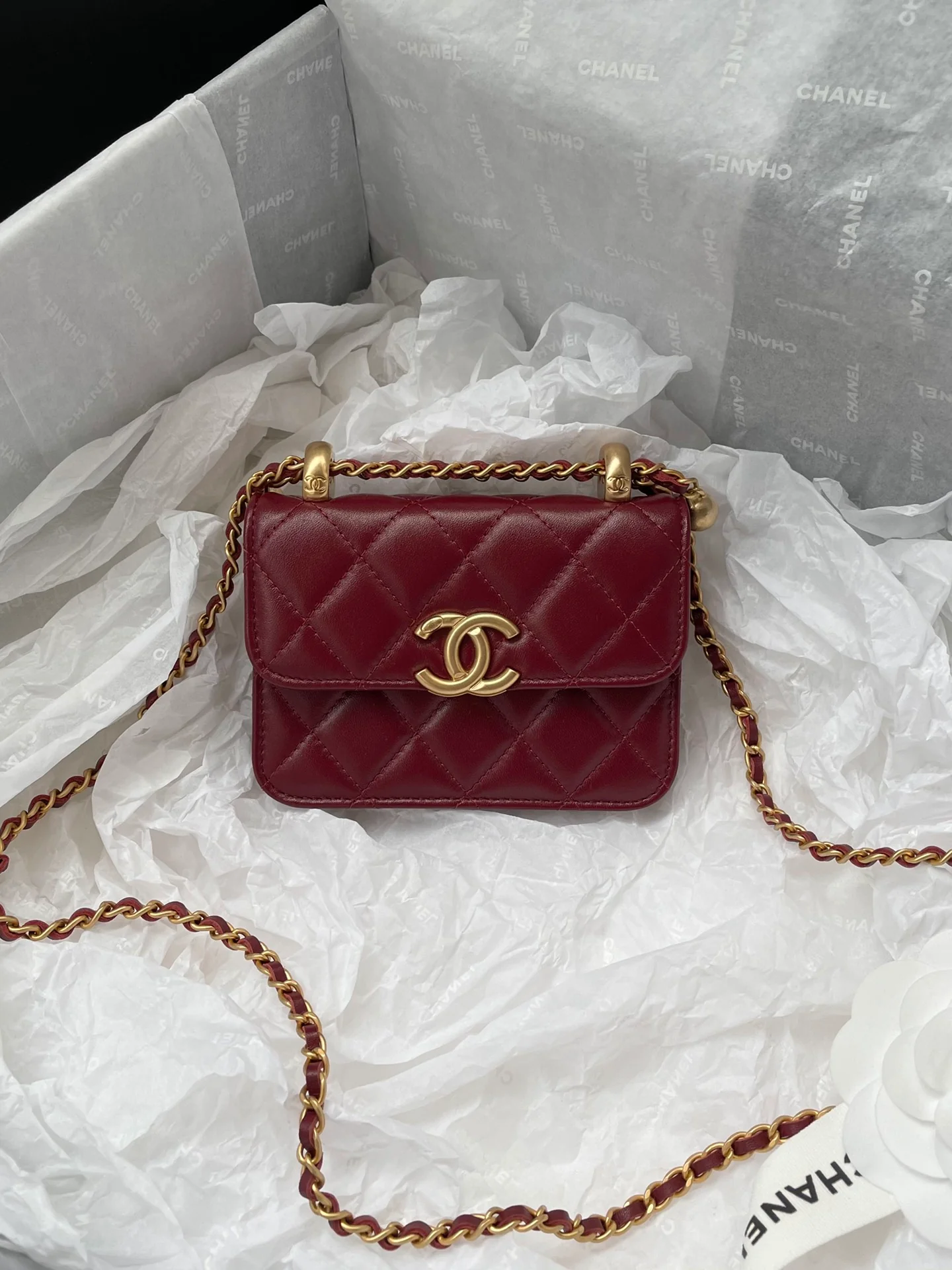 Держатель для карт Chanel с двойной золотой цепочкой и шариками, отделанный бордовой кожей.