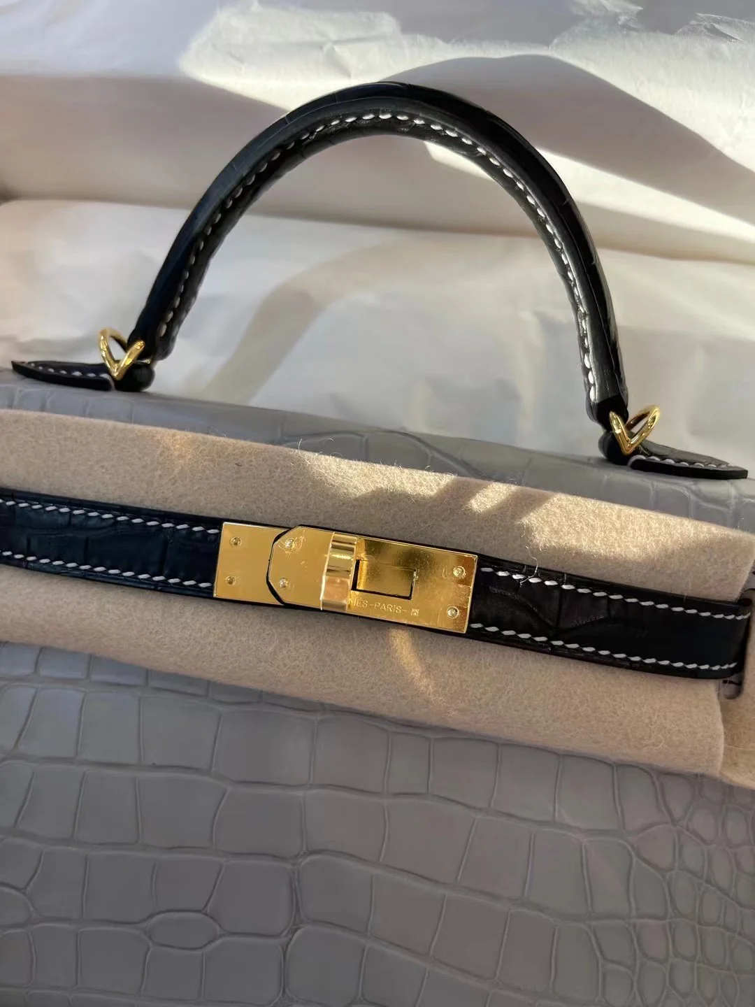 Миниатюрная сумка Hermes Kelly Mini 2-го поколения из матовой кожи аллигатора — жемчужно-серая и черная с золотой фурнитурой.