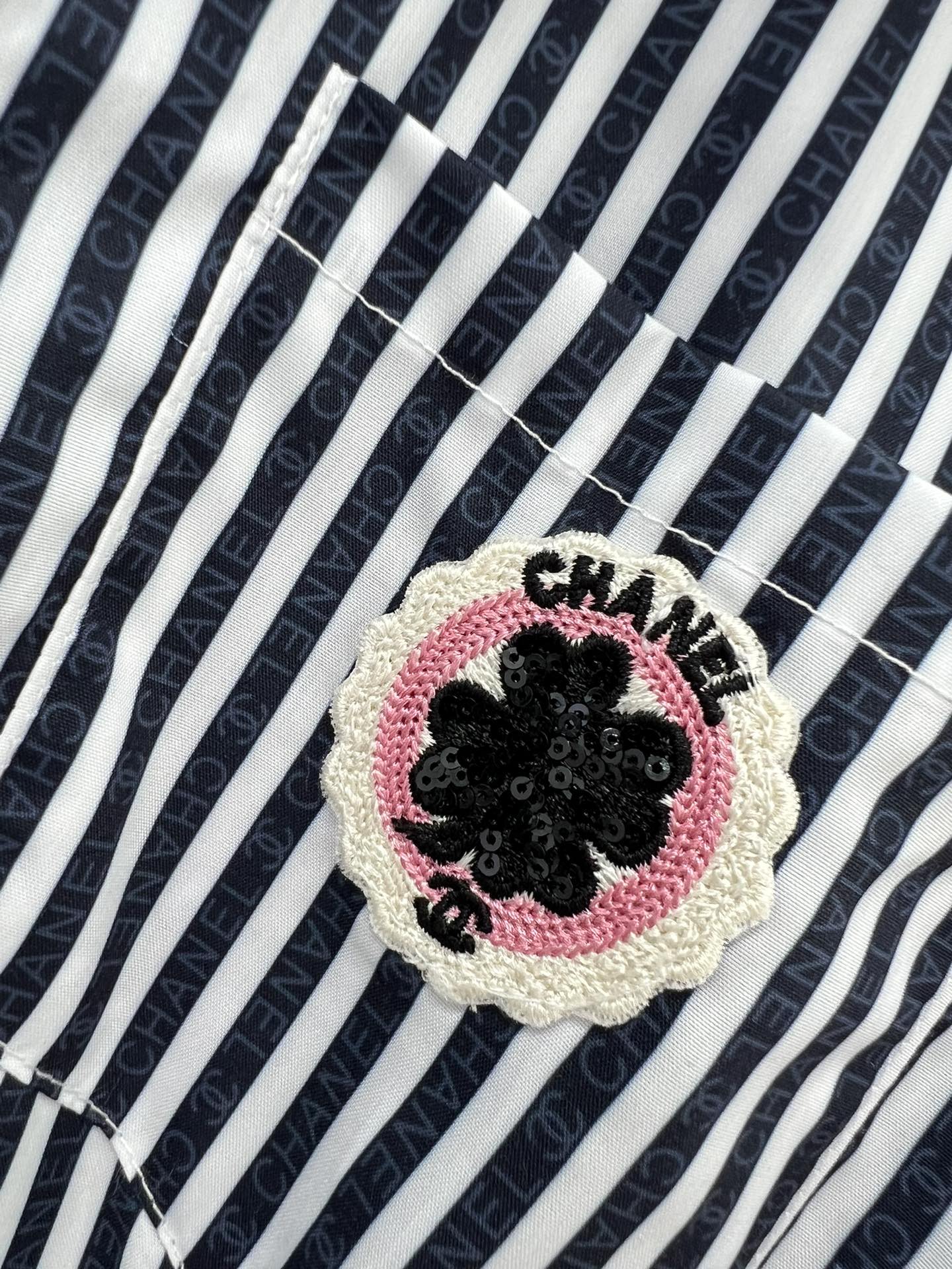 Новый комбинезон Chanel весна/лето 2024 с короткими рукавами, украшенный пайетками и принтом — в полоску.