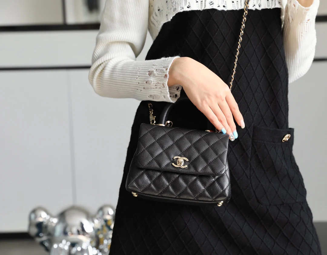 Мини-сумка Chanel Coco Handle — черная кожа с золотистой пряжкой.