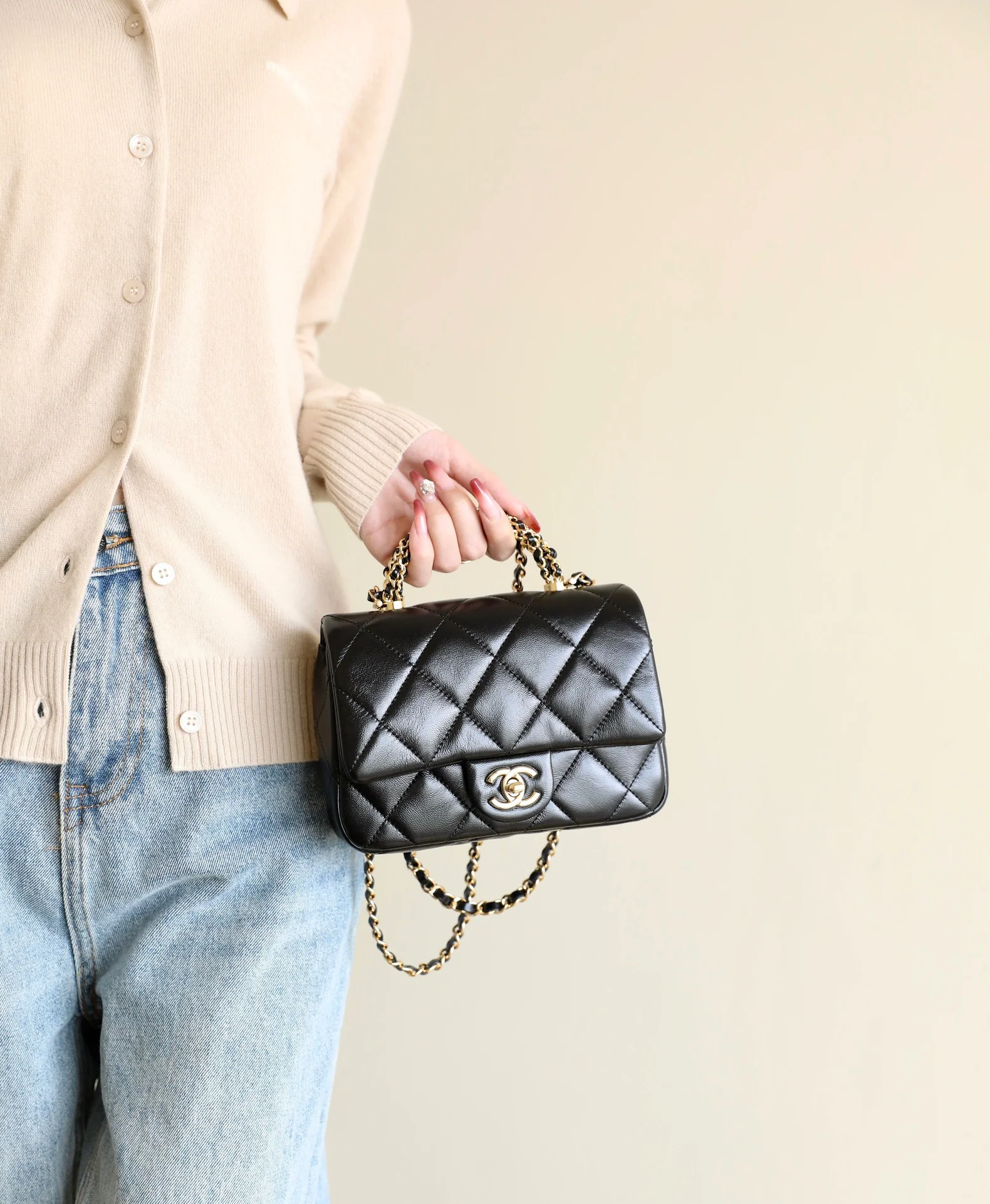 Маленькая черная сумка Chanel с клапаном и поворотной ручкой.