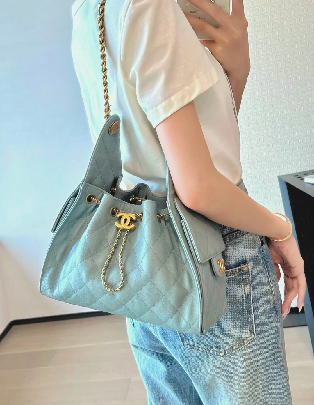 Маленькая сумка-шоппер Chanel — серо-голубая с золотой фурнитурой.