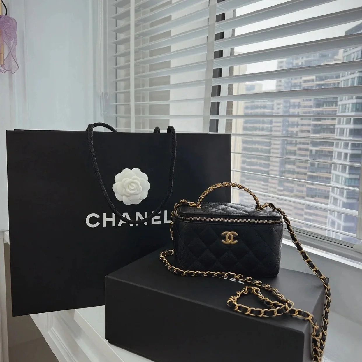 Длинная сумка-коробка Chanel из весенне-летней коллекции с ажурным логотипом на ручке — черная.