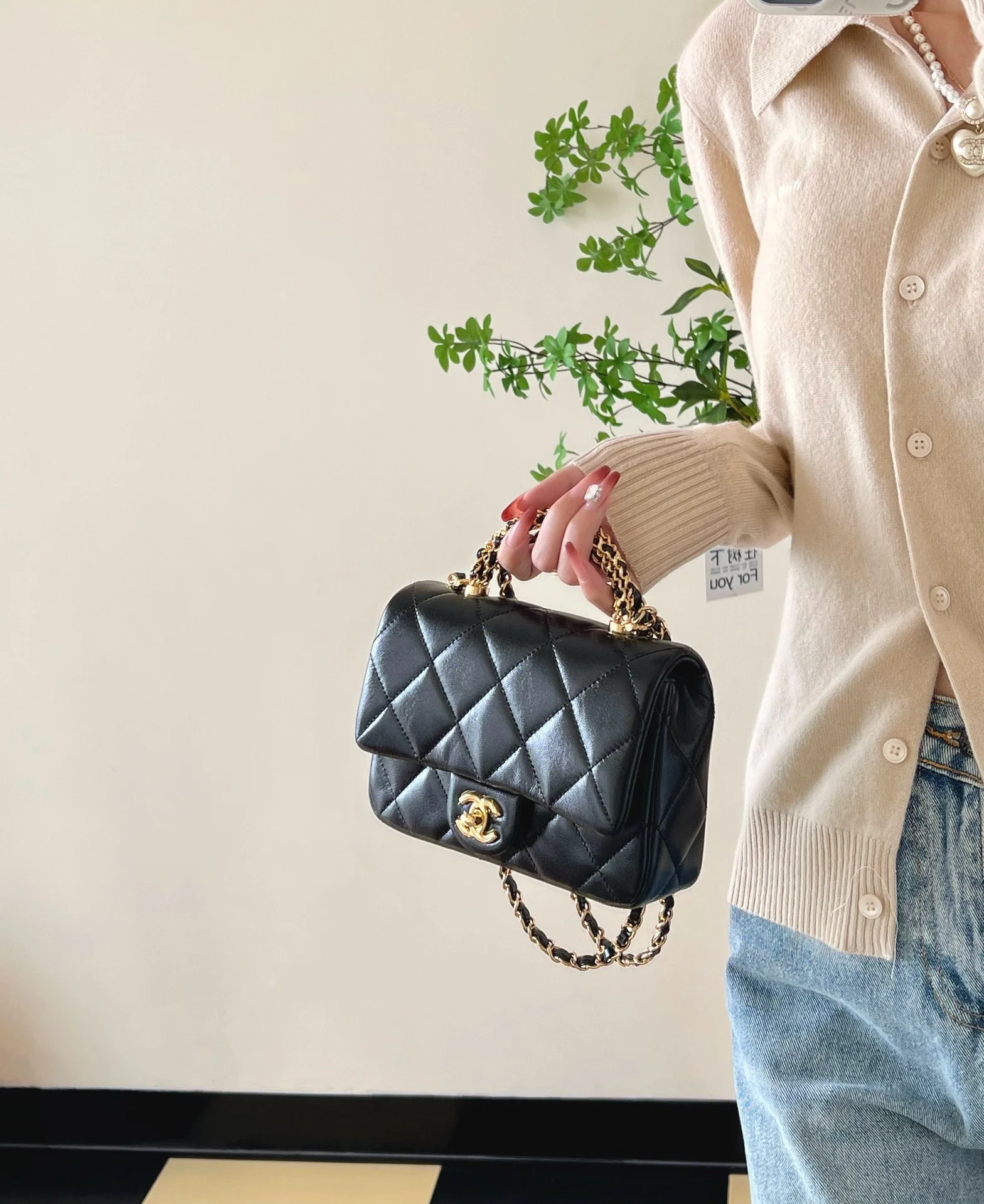 Маленькая черная сумка Chanel с клапаном и поворотной ручкой.