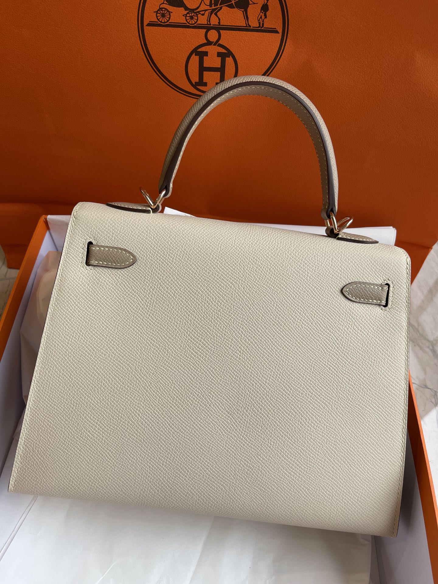 Hermes Kelly 25 Epsom Milkshake White с серым тренчем и пряжками из розового золота.