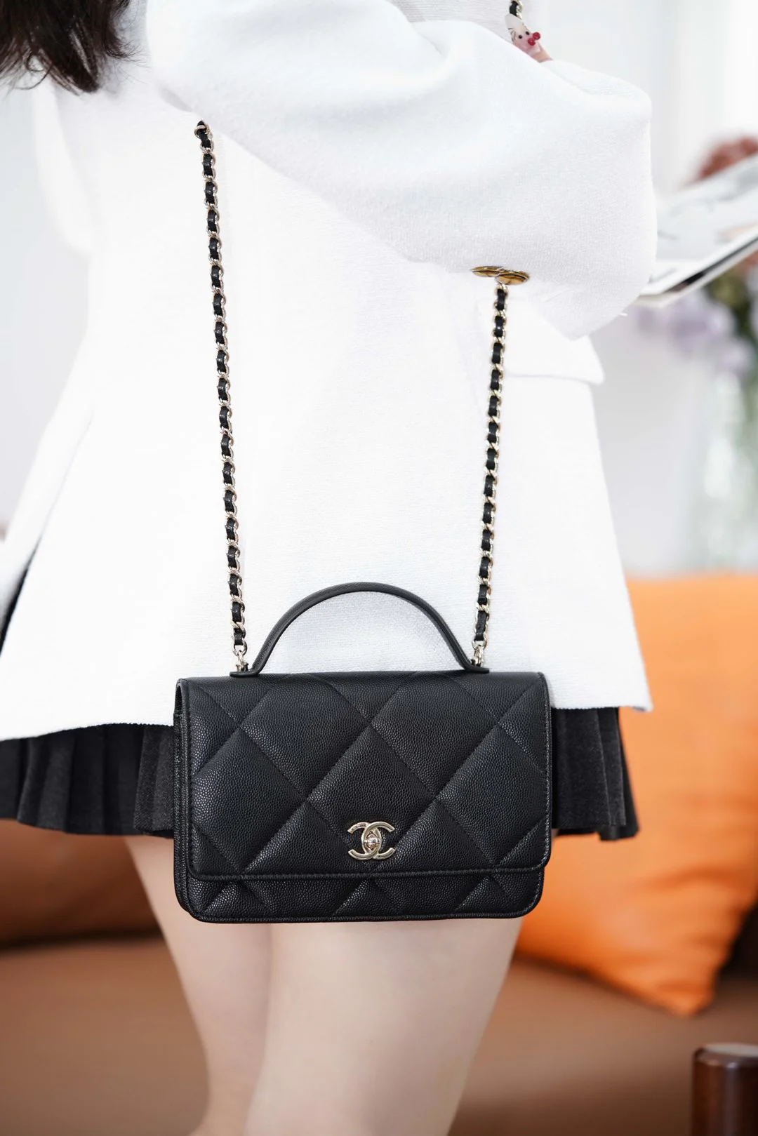 Ручка сумки Chanel из 25-каратного золота с ромбовидным узором, черная сумка-корзина с золотой фурнитурой.