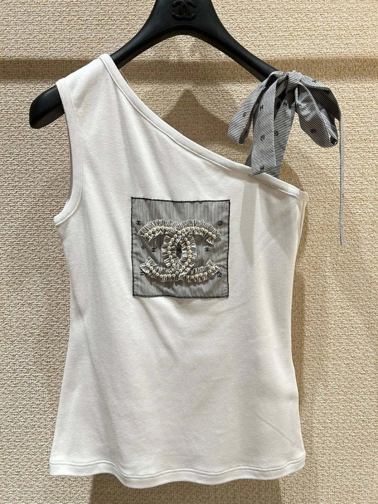 Новая коллекция Chanel весна/лето 2024: майка с открытыми плечами, украшенная бисером и логотипом.