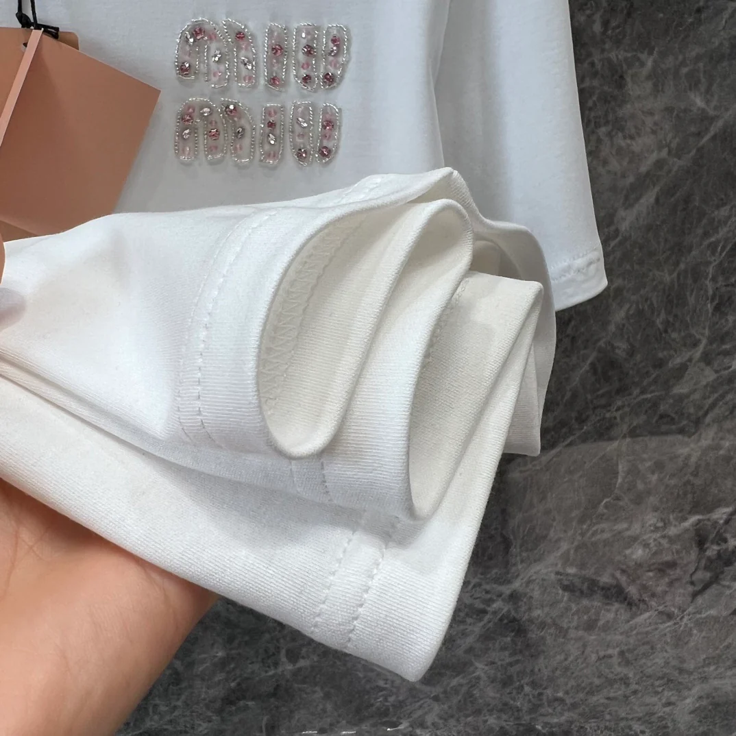 Miu Miu-2404 - Розовая атласная футболка с короткими рукавами и бантом из ленты, украшенная стразами в виде букв.