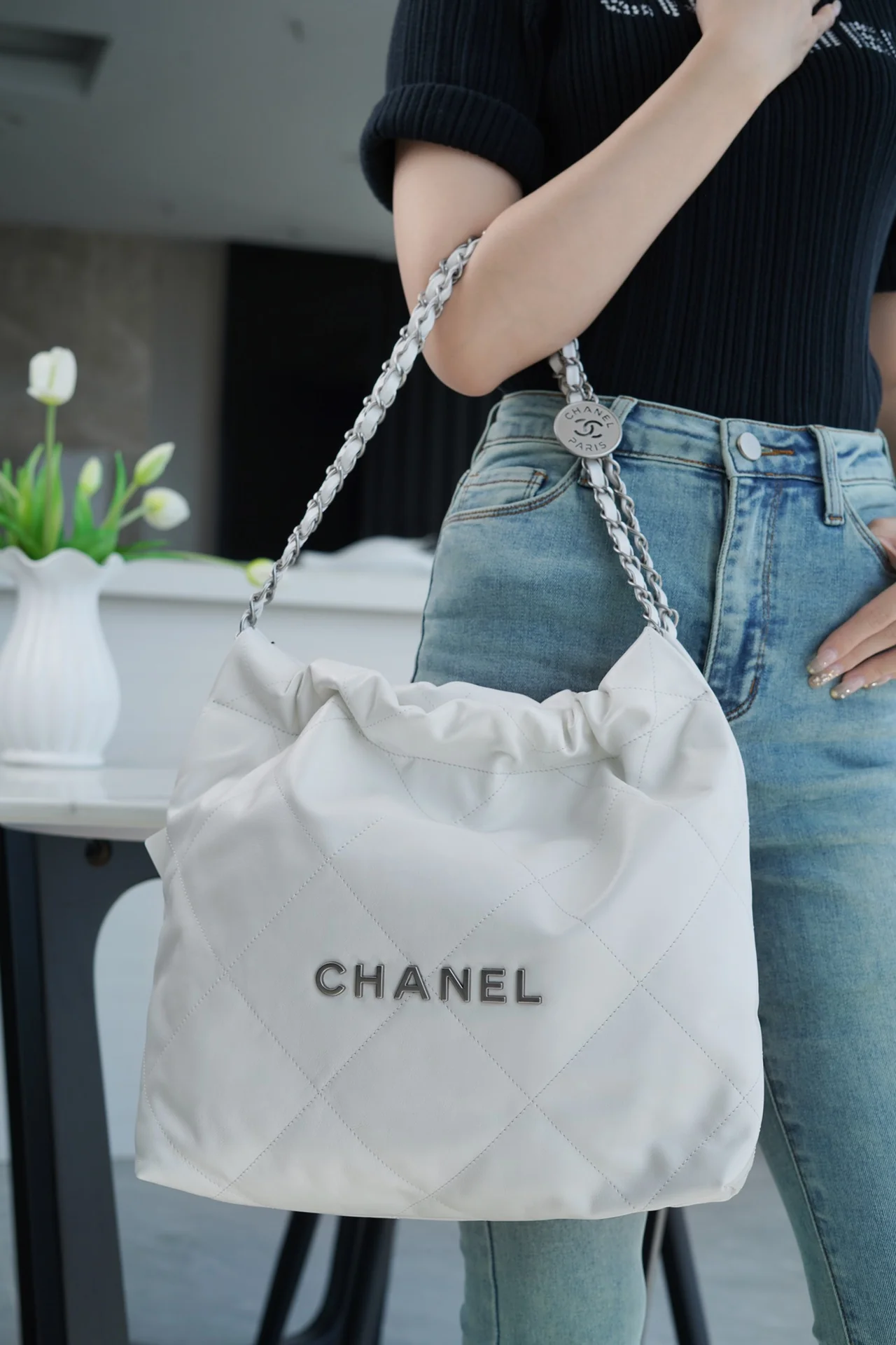 Сумочка Chanel No. 22 — маленькая, белая, серебристая.