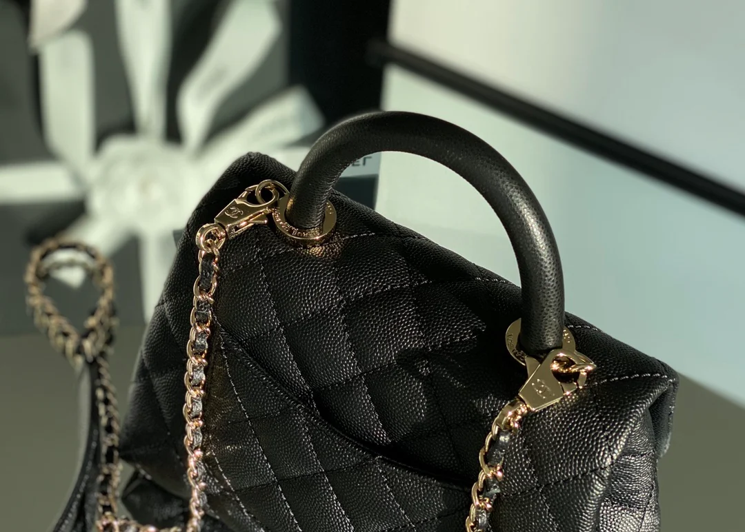Мини-сумка Chanel Coco Handle — черная кожа с золотистой пряжкой.