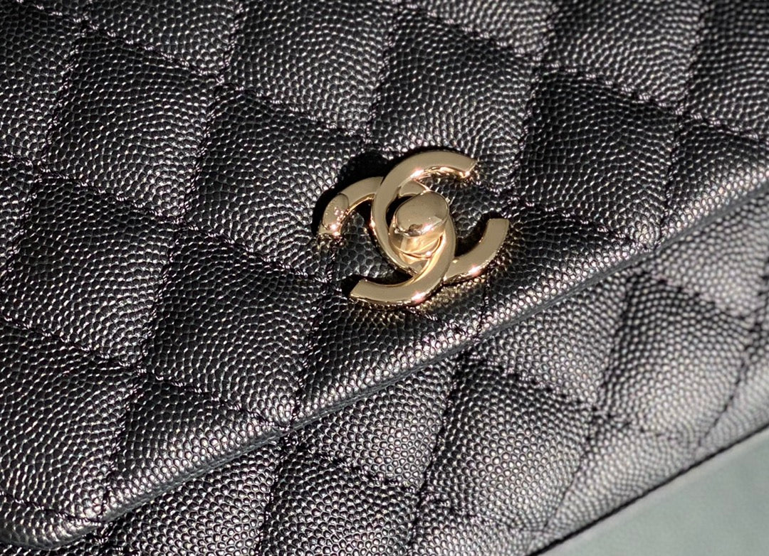 Мини-сумка Chanel Coco Handle — черная кожа с золотистой пряжкой.