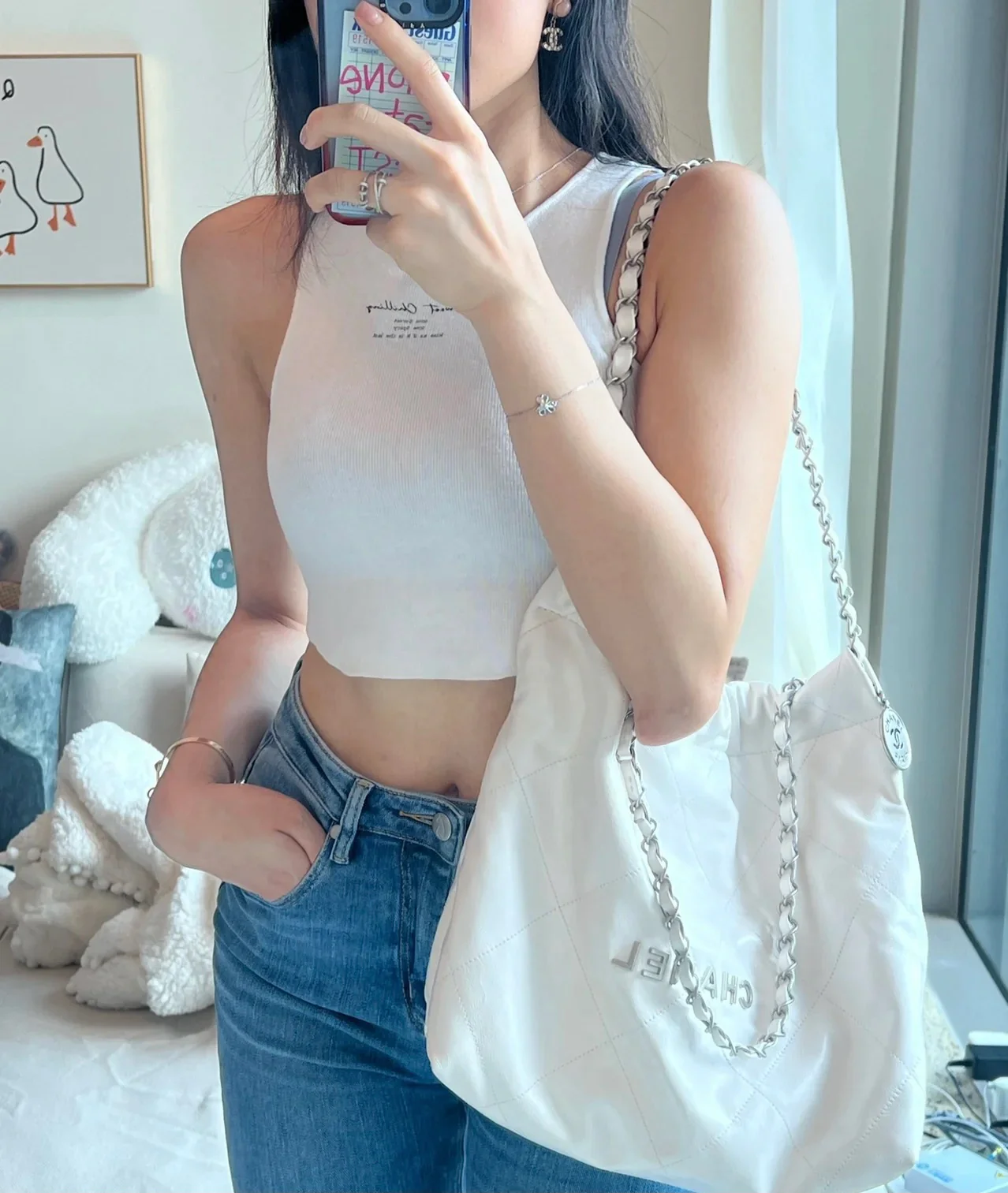 Сумочка Chanel No. 22 — маленькая, белая, серебристая.