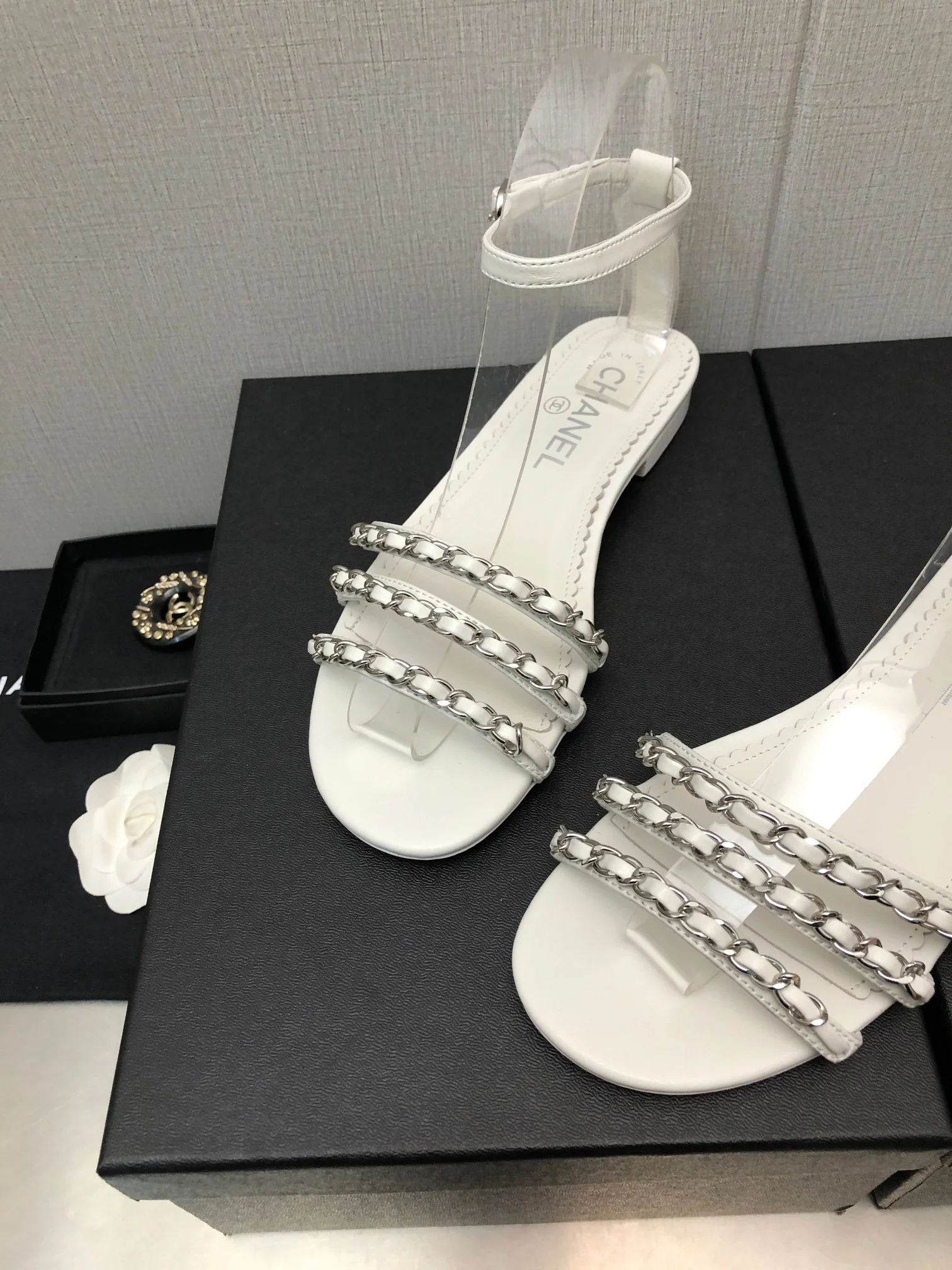 Новинка весны 2023 года от Chanel - сандалии на плоской подошве с цепочкой - белые.