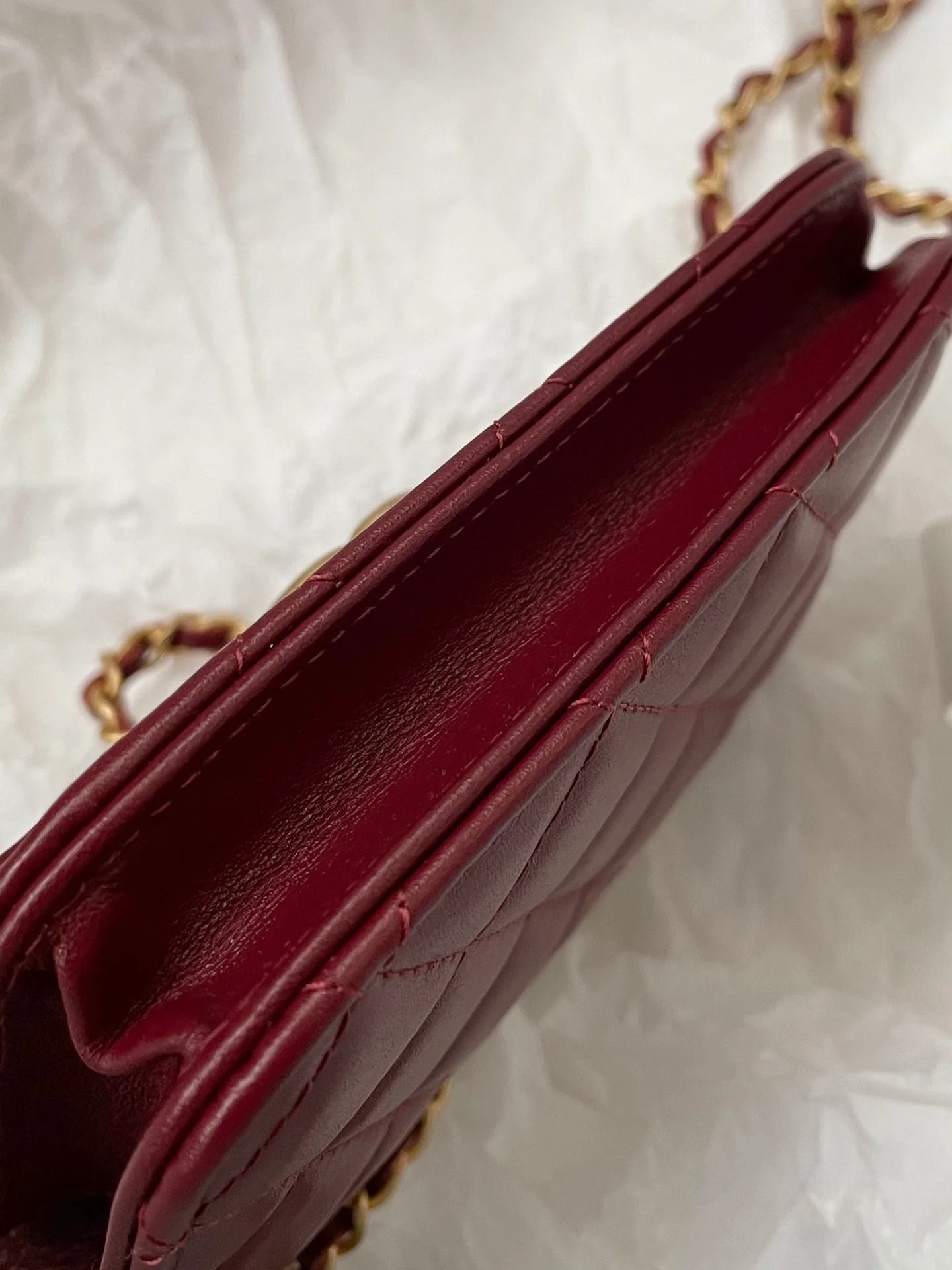 Держатель для карт Chanel с двойной золотой цепочкой и шариками, отделанный бордовой кожей.