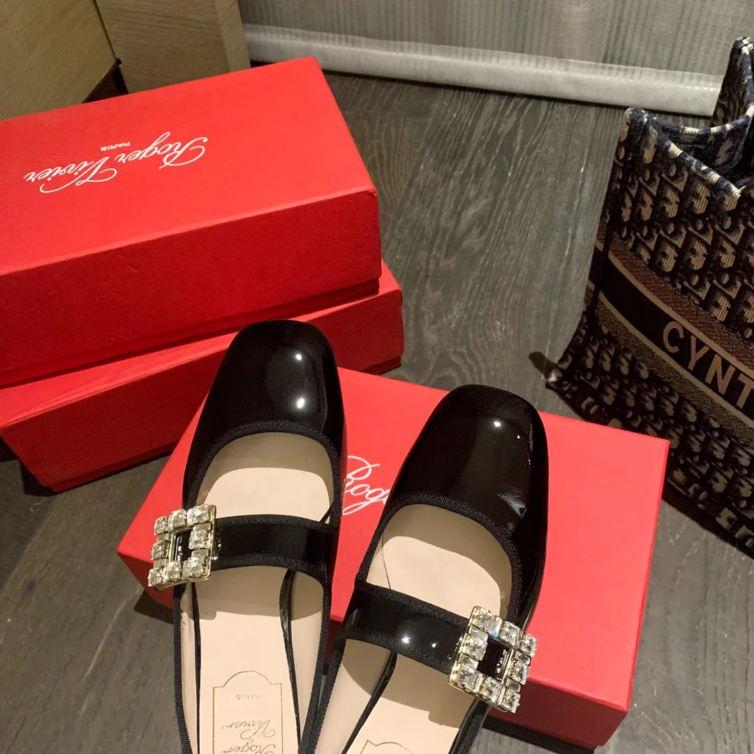 Лакированные балетки с пряжками, украшенными стразами — черные.