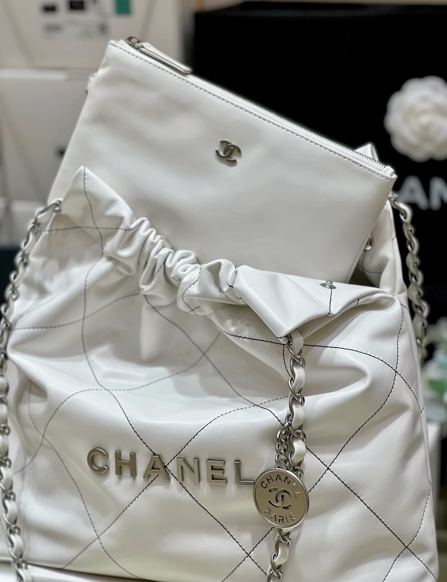 Сумка Chanel из круизной коллекции 2023 года - модель 22bag - белая с черной строчкой.
